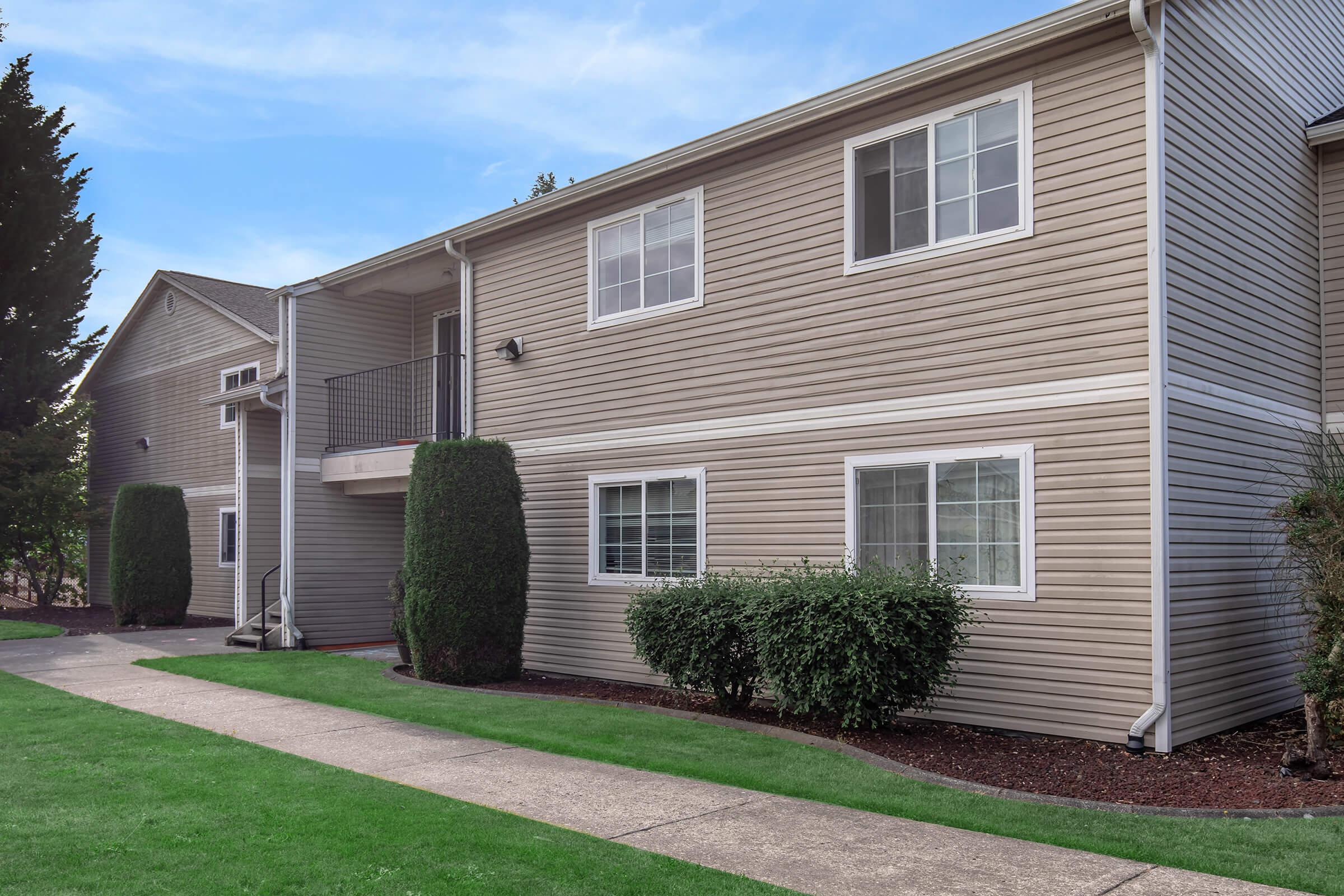 a large brick building with grass in front of a house