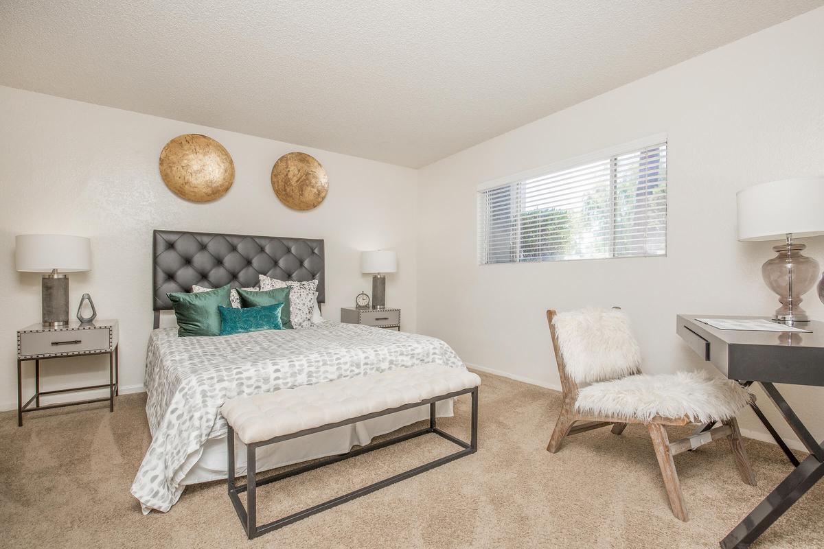 a bedroom with a bed and desk in a room