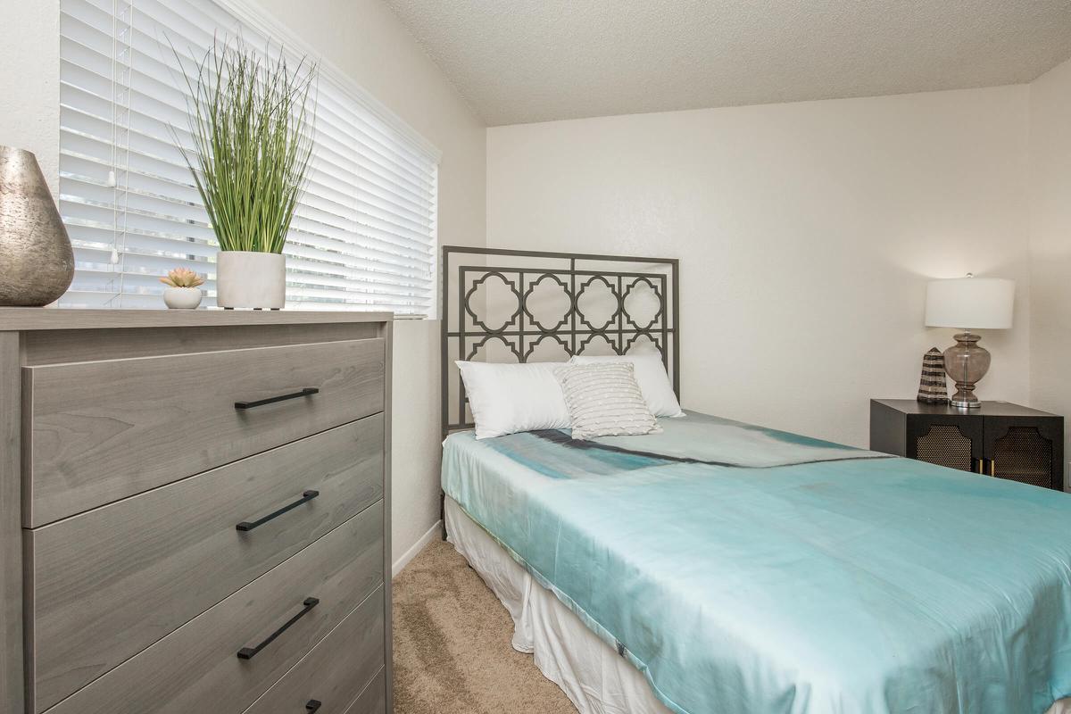 a bedroom with a bed and desk in a room