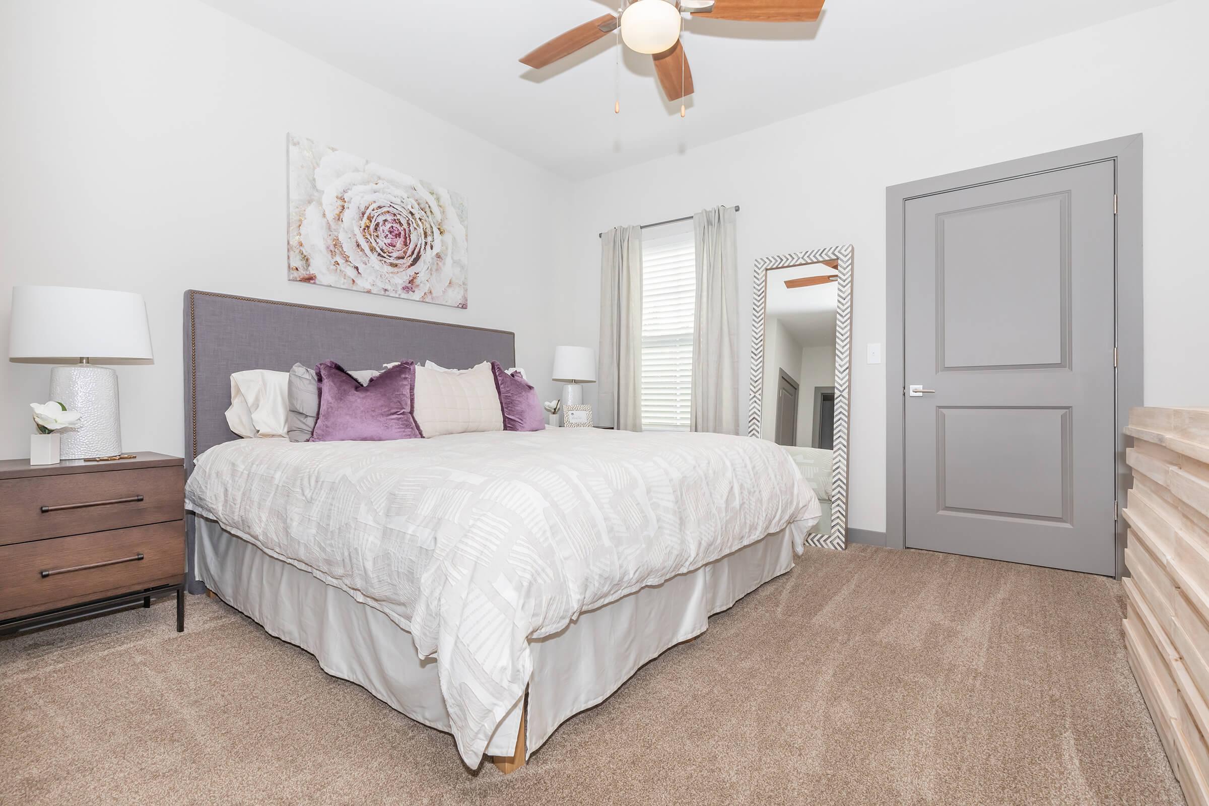a bedroom with a bed and desk in a room