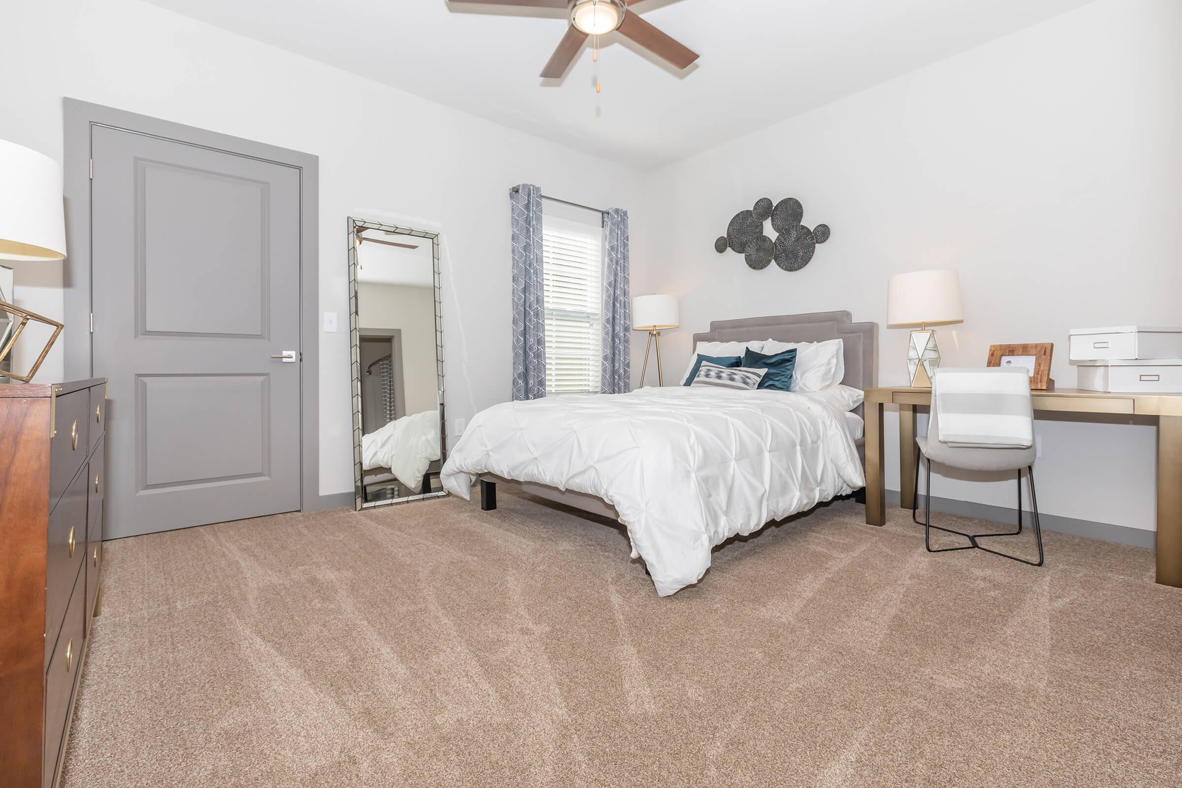a bedroom with a bed and desk in a room