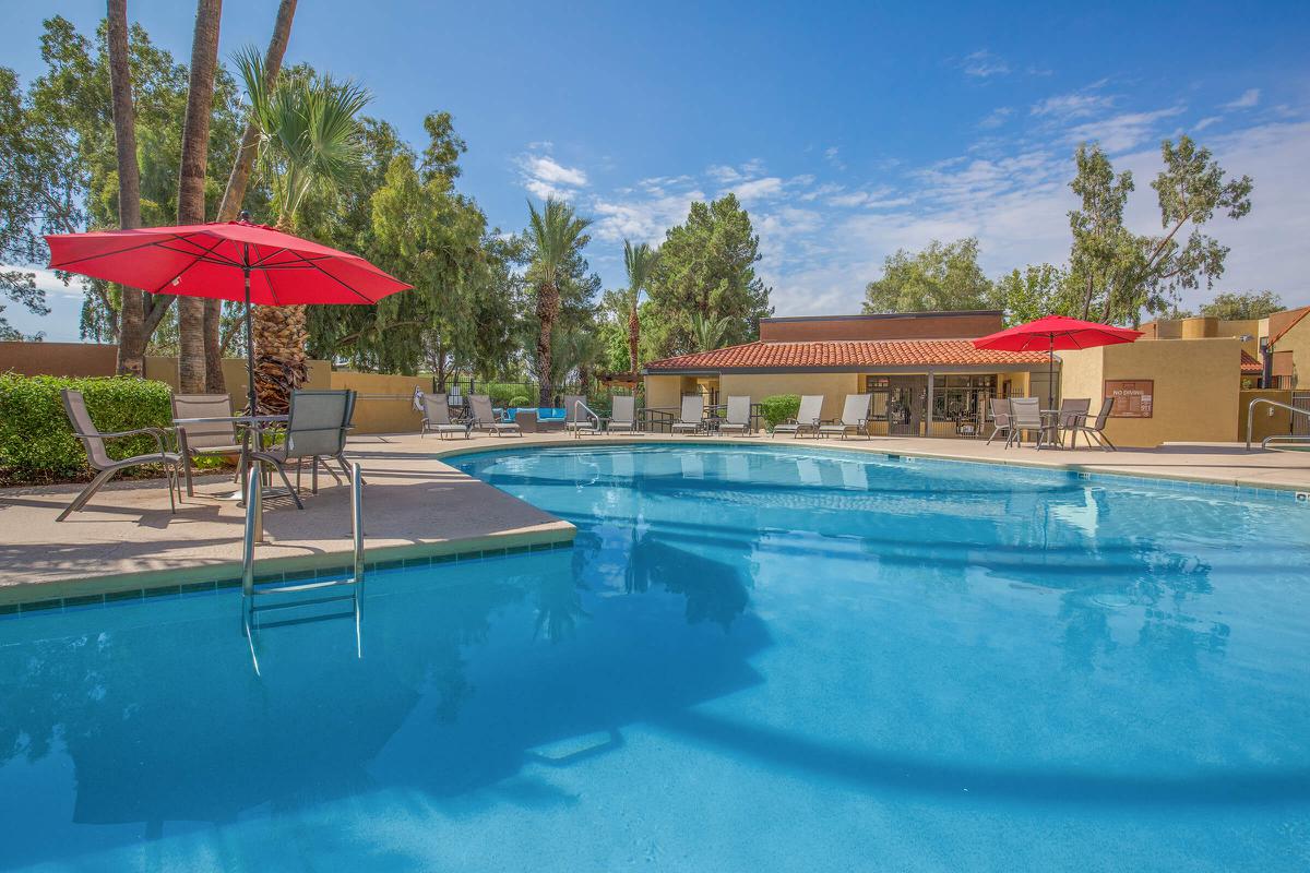 a red umbrella next to a pool of water