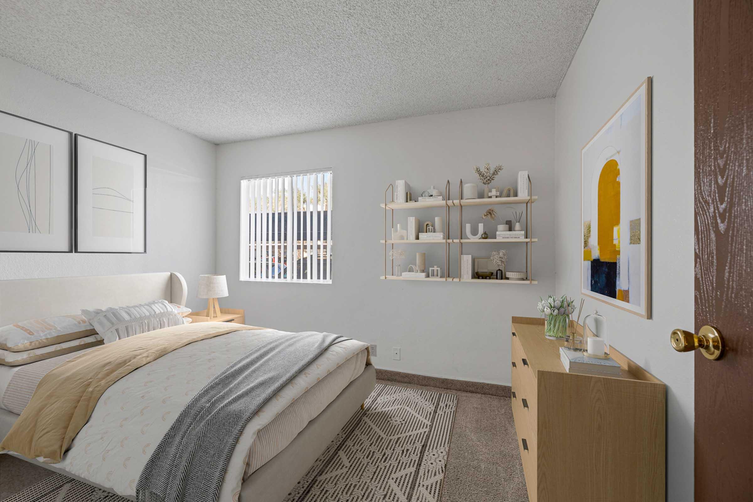 A cozy bedroom featuring a bed with neutral bedding, a bedside lamp, and artwork on the walls. A shelf with decorative items is mounted on the wall, and a wooden dresser sits nearby. Natural light filters through a window with blinds, creating a warm and inviting atmosphere.