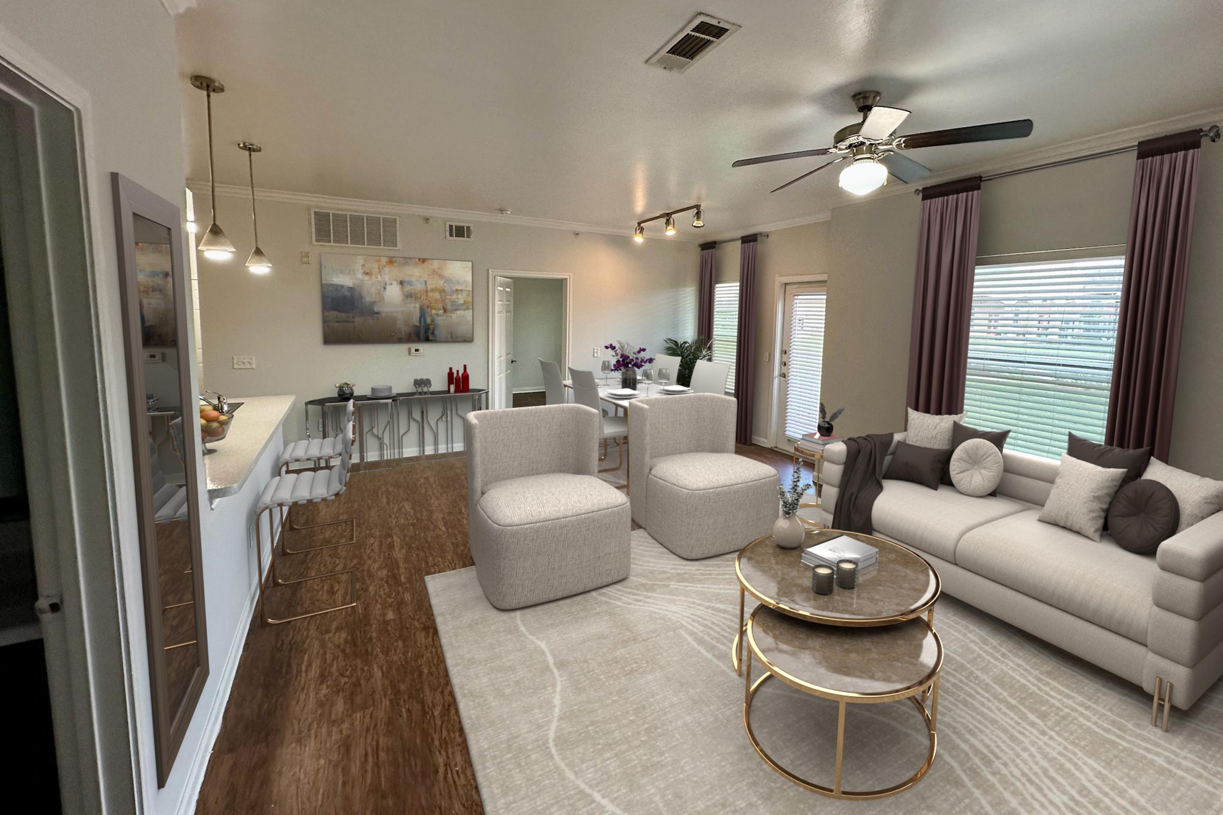 A modern living room with light-colored walls, featuring a comfortable gray sofa, two upholstered chairs, a round coffee table, and a decorative rug. The open layout connects to a dining area with a table and chairs. Natural light fills the space through large windows, and stylish pendant lights hang from the ceiling.