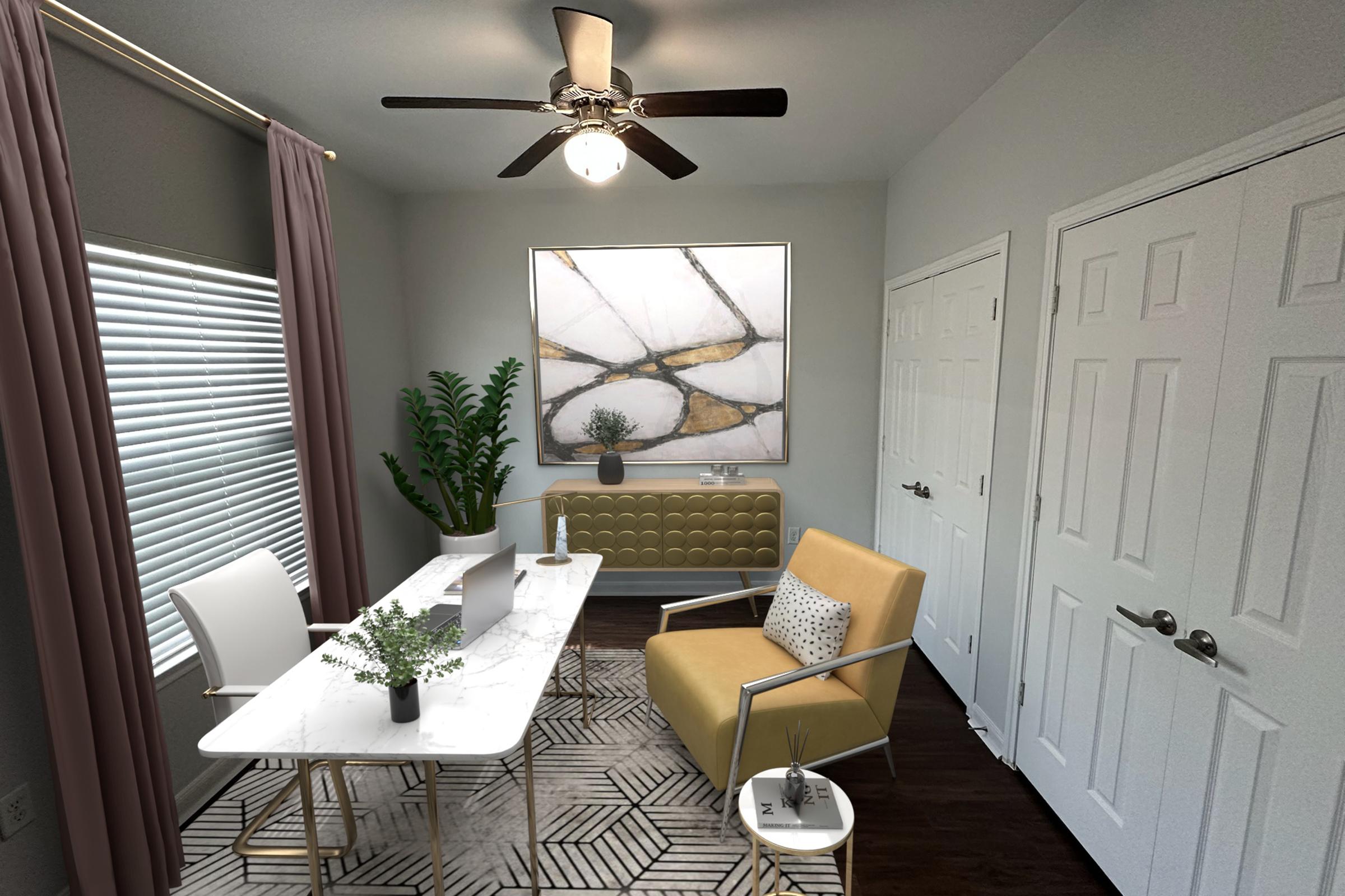 Modern home office featuring a white marble table with décor and a potted plant, a yellow chair, and a geometric rug. A large artwork adorns the wall, complemented by a ceiling fan and natural light from a nearby window with sheer curtains. Two white doors are visible in the background.