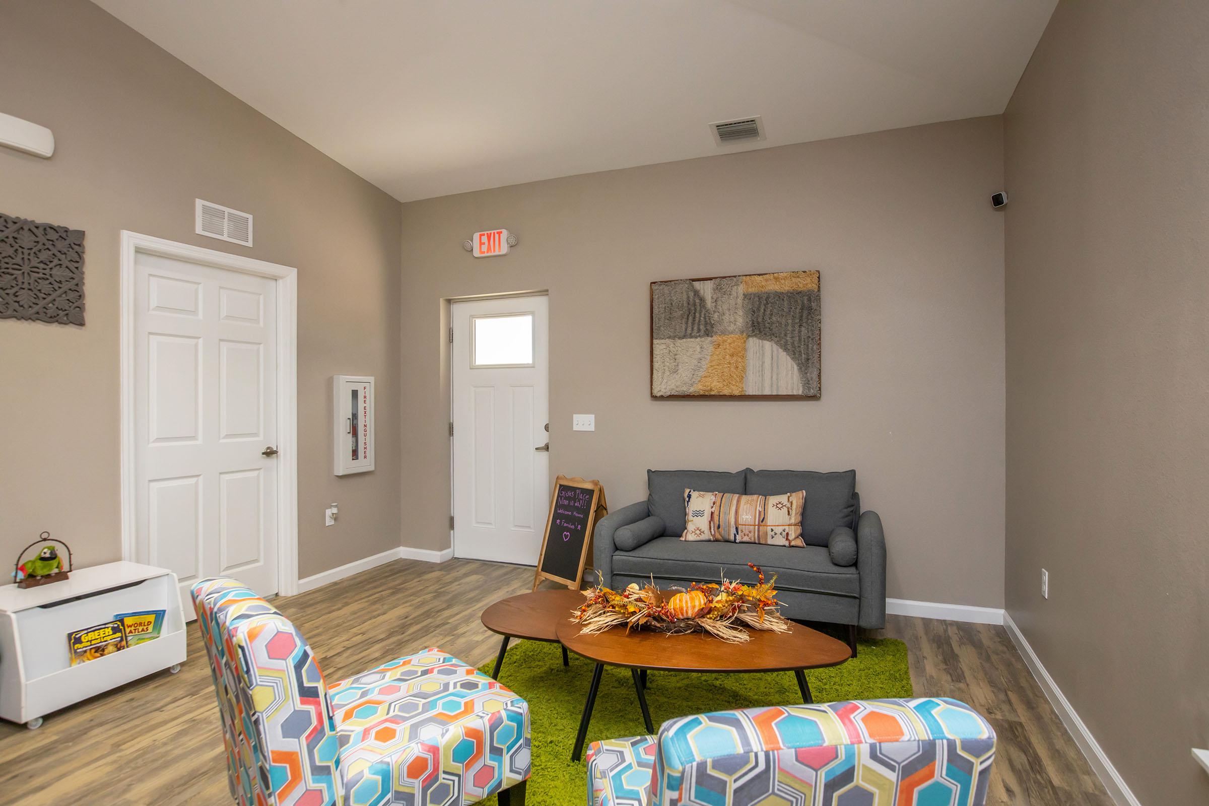 a living room filled with furniture and a painting on the wall