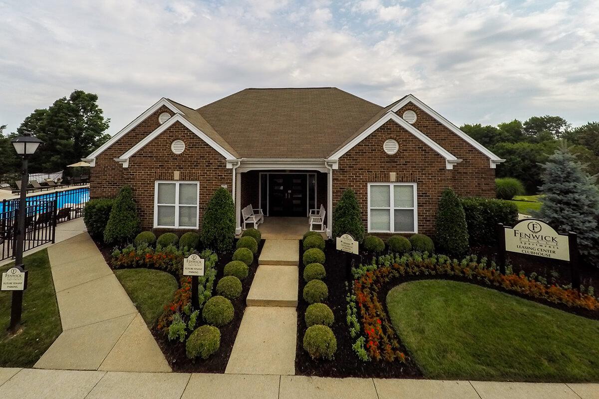 a large brick building with grass in front of a house