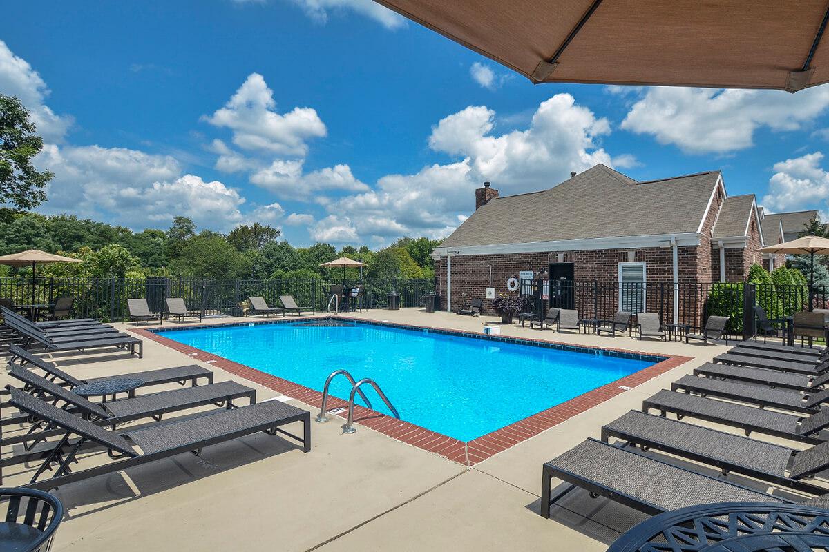 a row of lawn chairs sitting next to a pool of water
