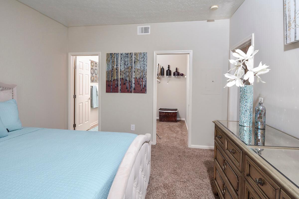a bedroom with a bed and a mirror in a room