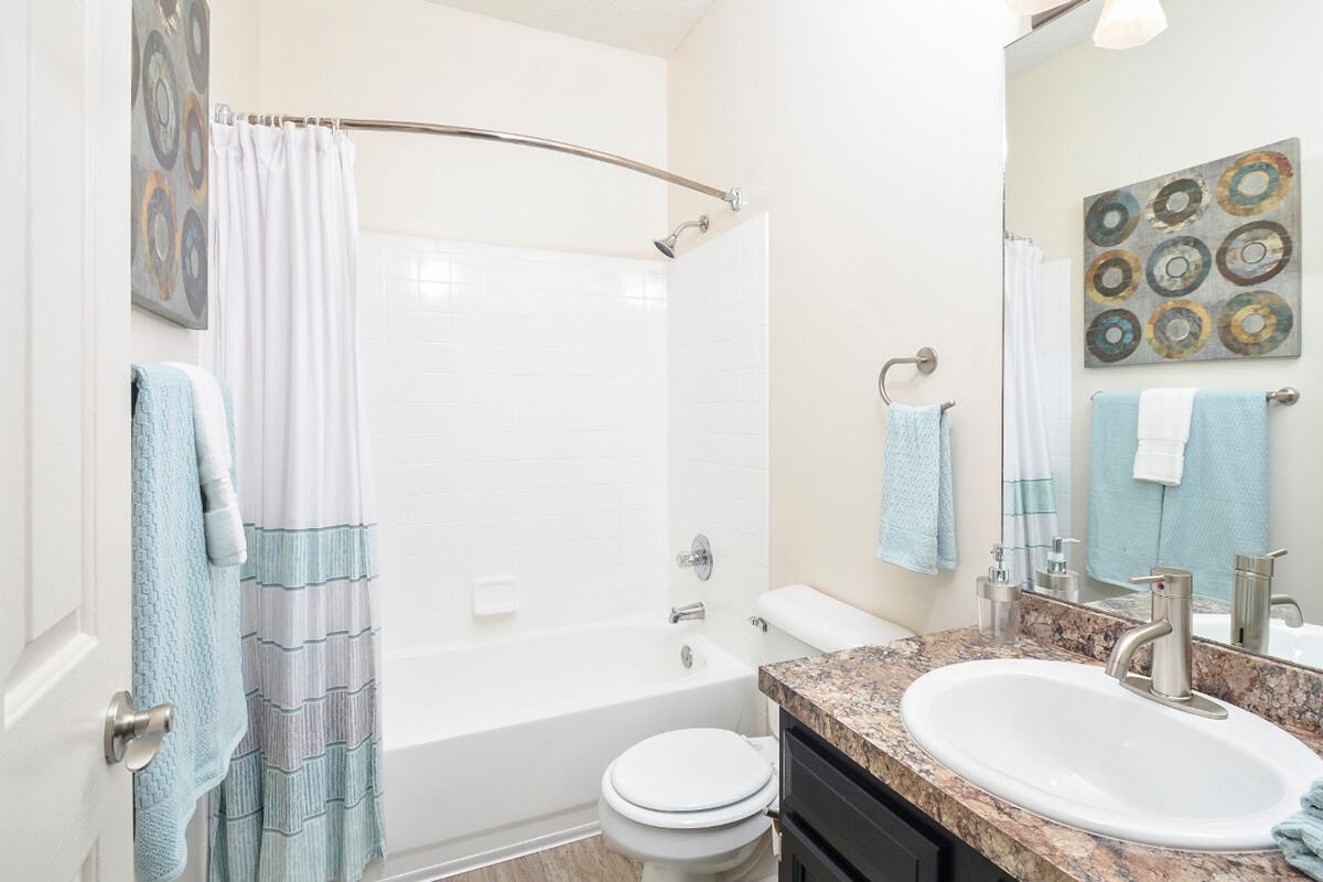a white sink sitting next to a shower