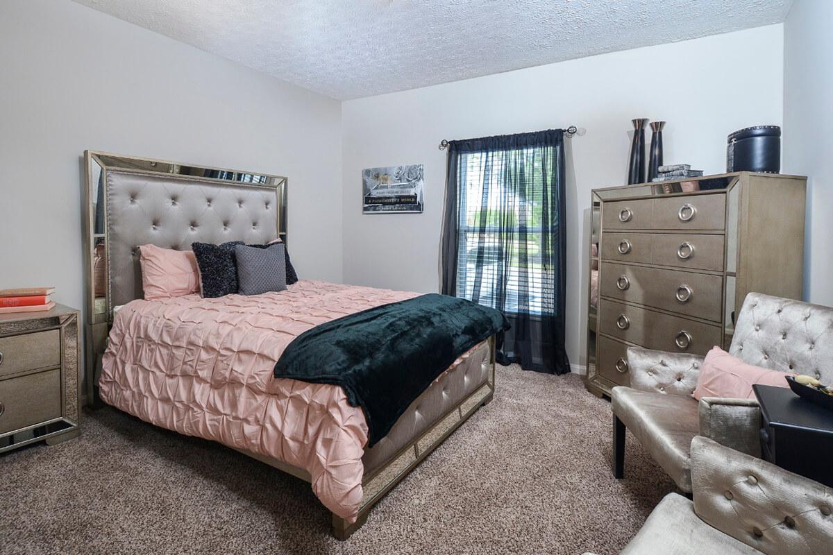 a bedroom with a bed and desk in a room