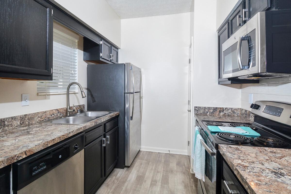 a modern kitchen with stainless steel appliances and wooden cabinets