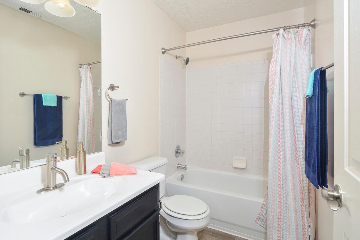 a white sink sitting next to a shower