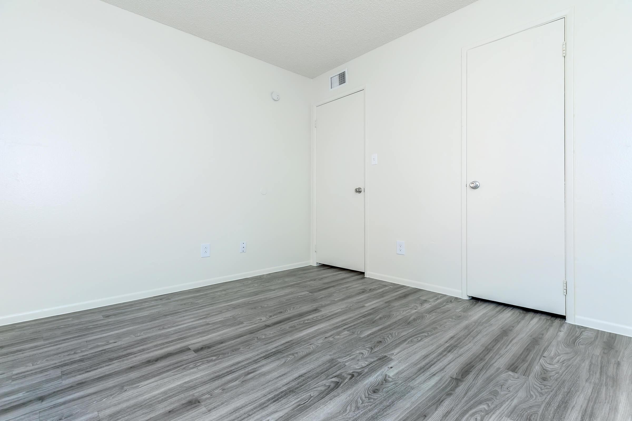 a bedroom with a wooden floor
