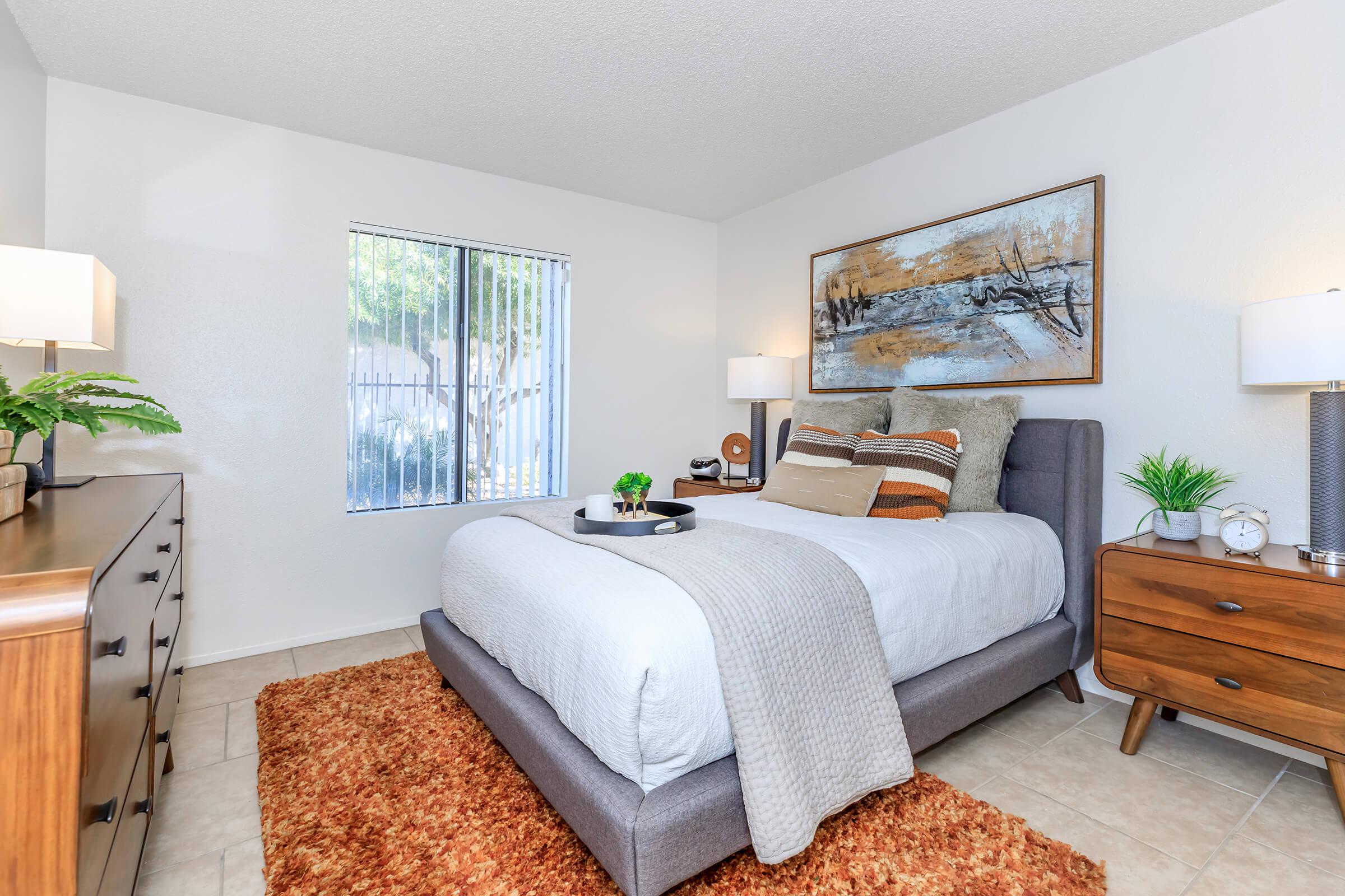 a bedroom with a bed and desk in a room