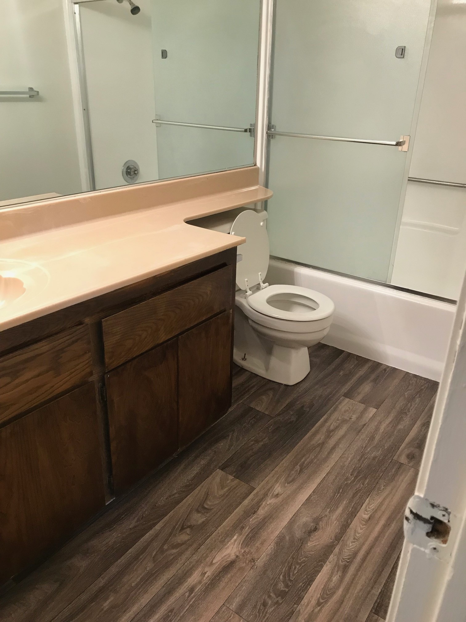 Bathroom with wooden cabinets and sliding glass shower doors