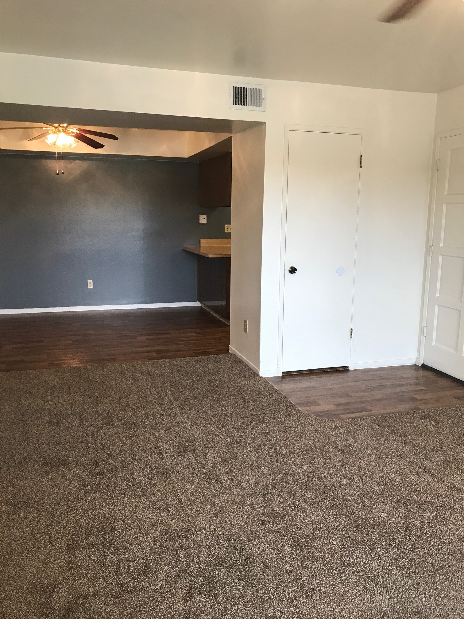 Vacant apartment with wooden and carpeted floors