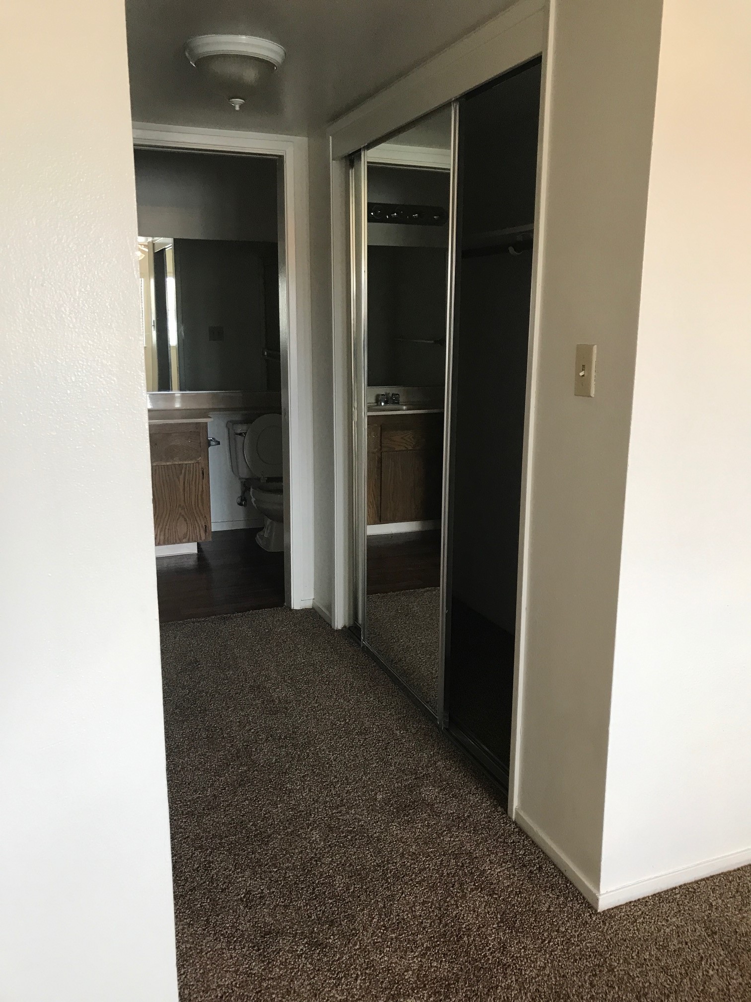 Open sliding mirror glass closet doors and bathroom door