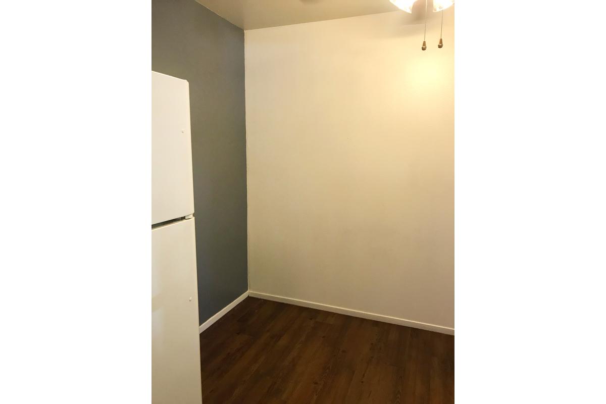 White refrigerator with wooden floors