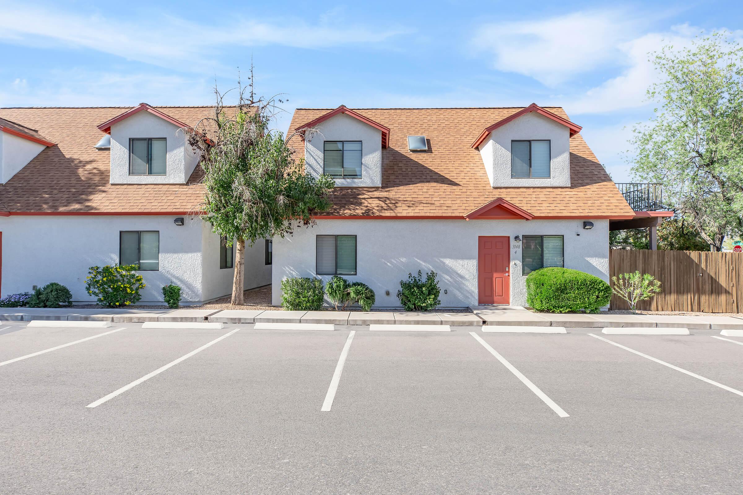 an empty parking lot in front of a house