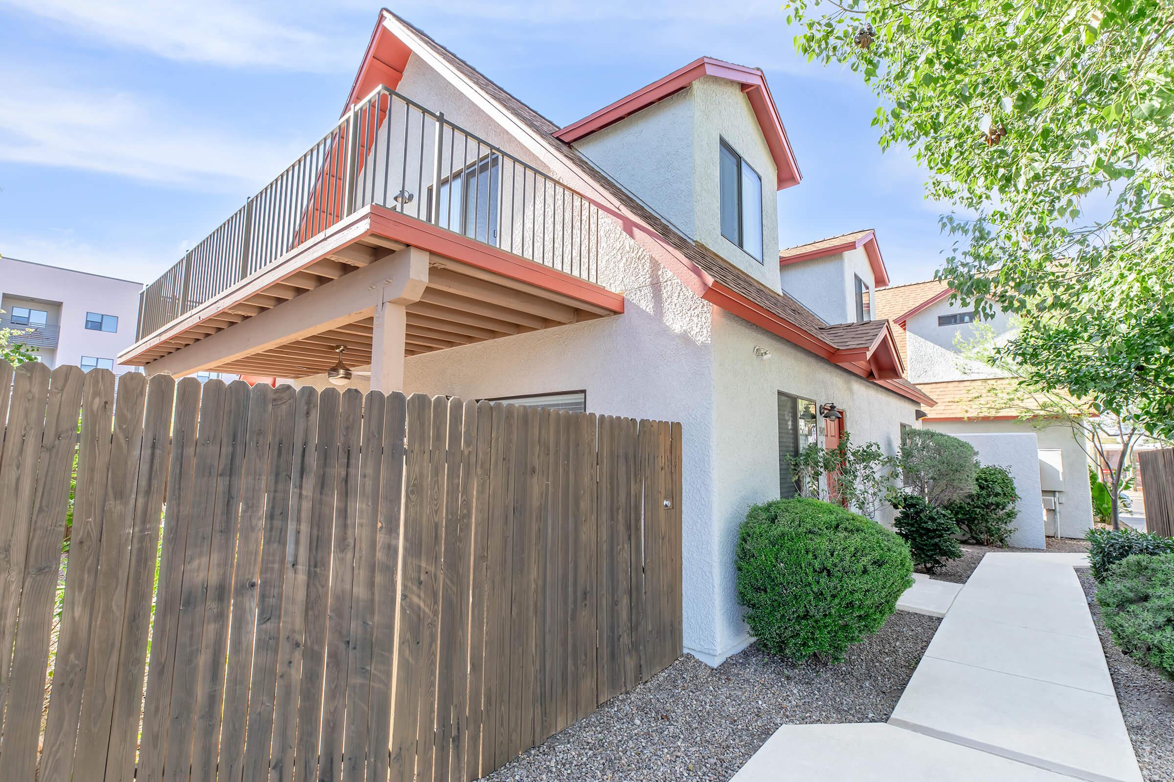 a house with a fence in front of a building