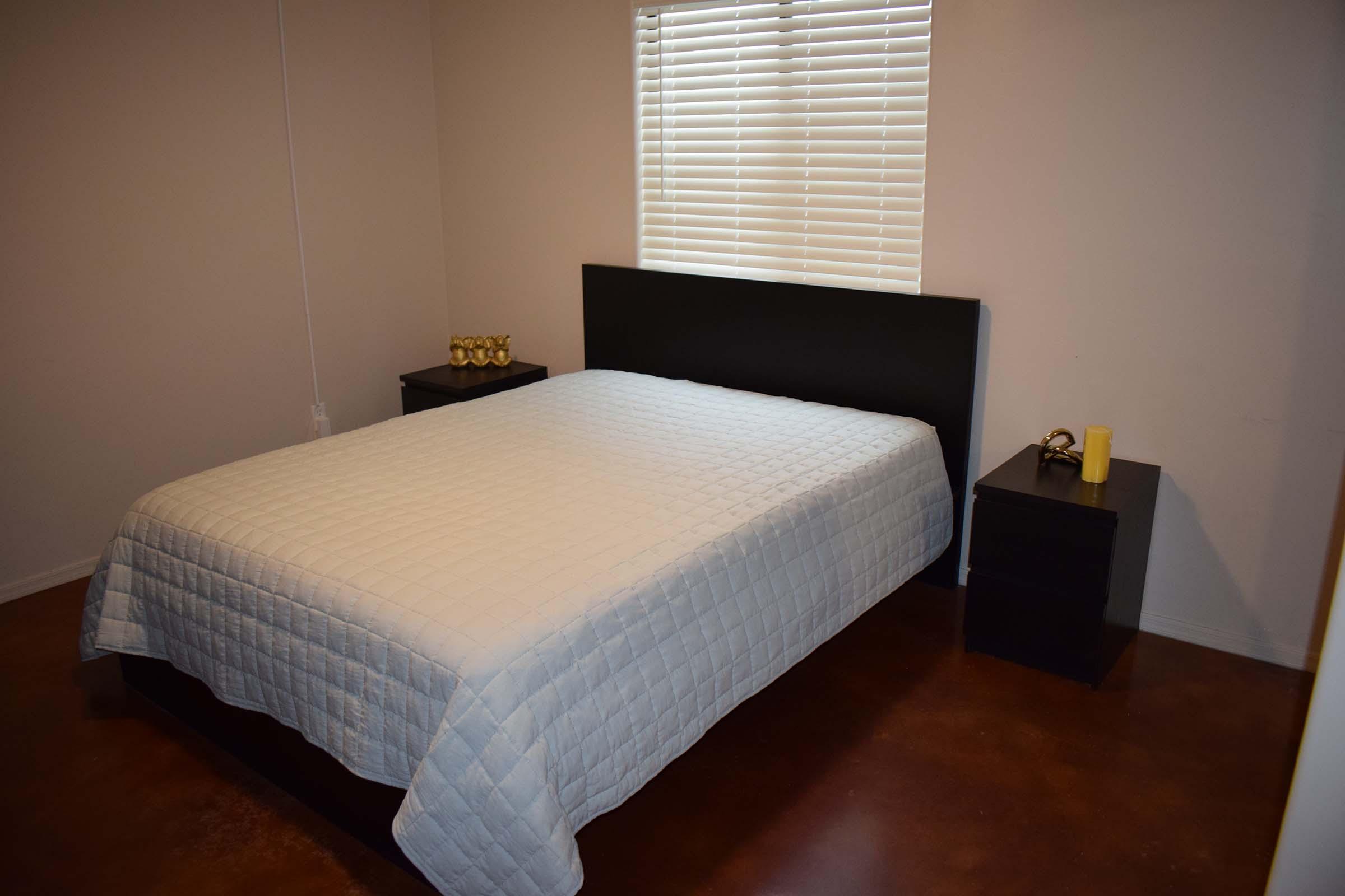 a bedroom with a bed and desk in a small room