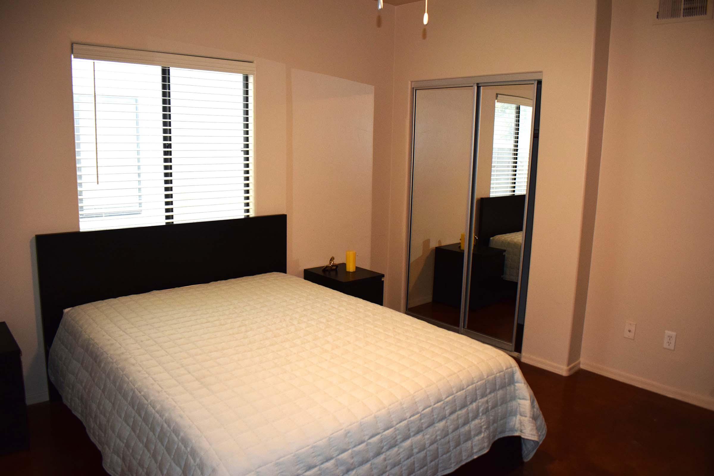 a bedroom with a bed and desk in a hotel room