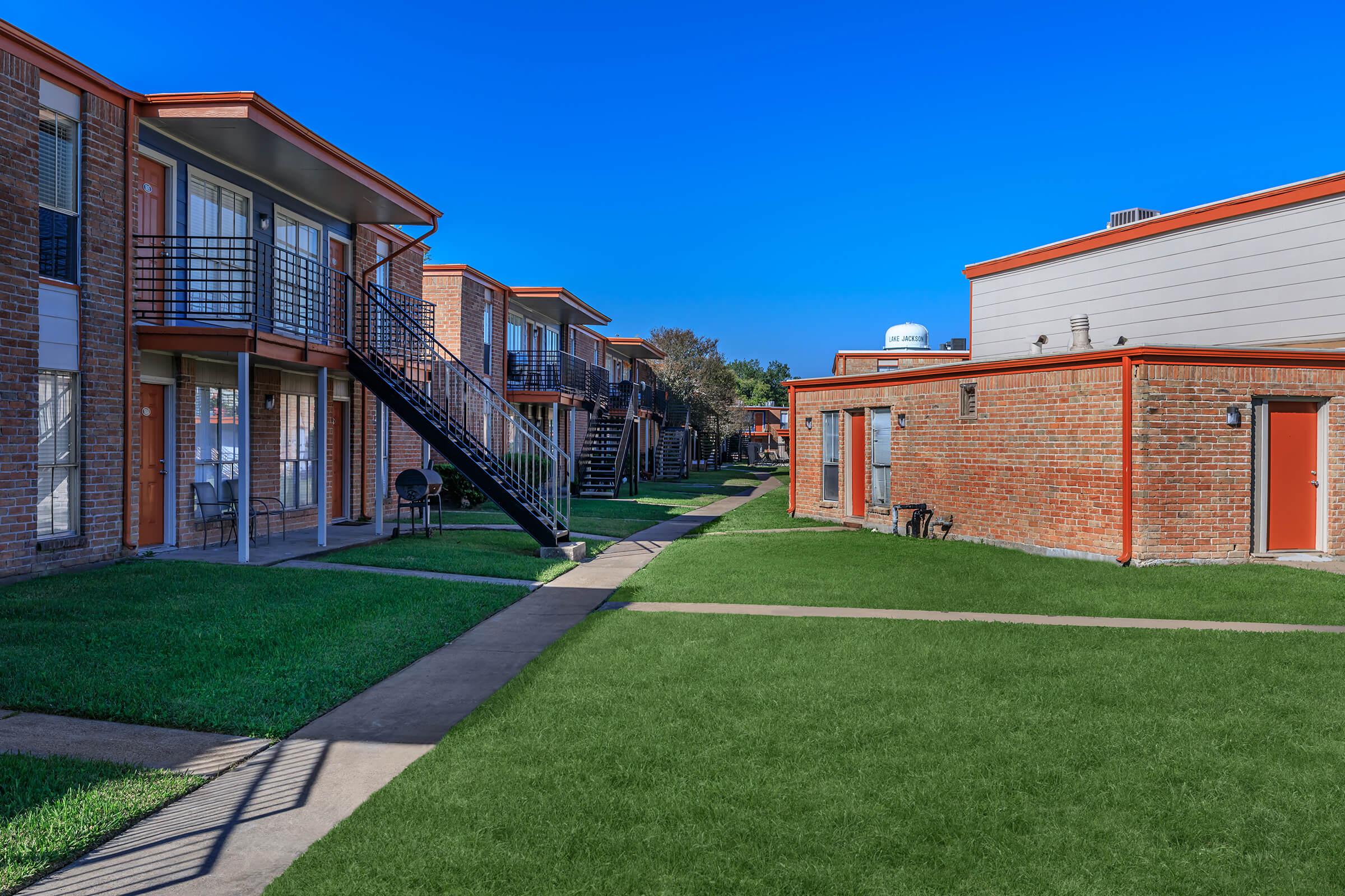 a large lawn in front of a brick building