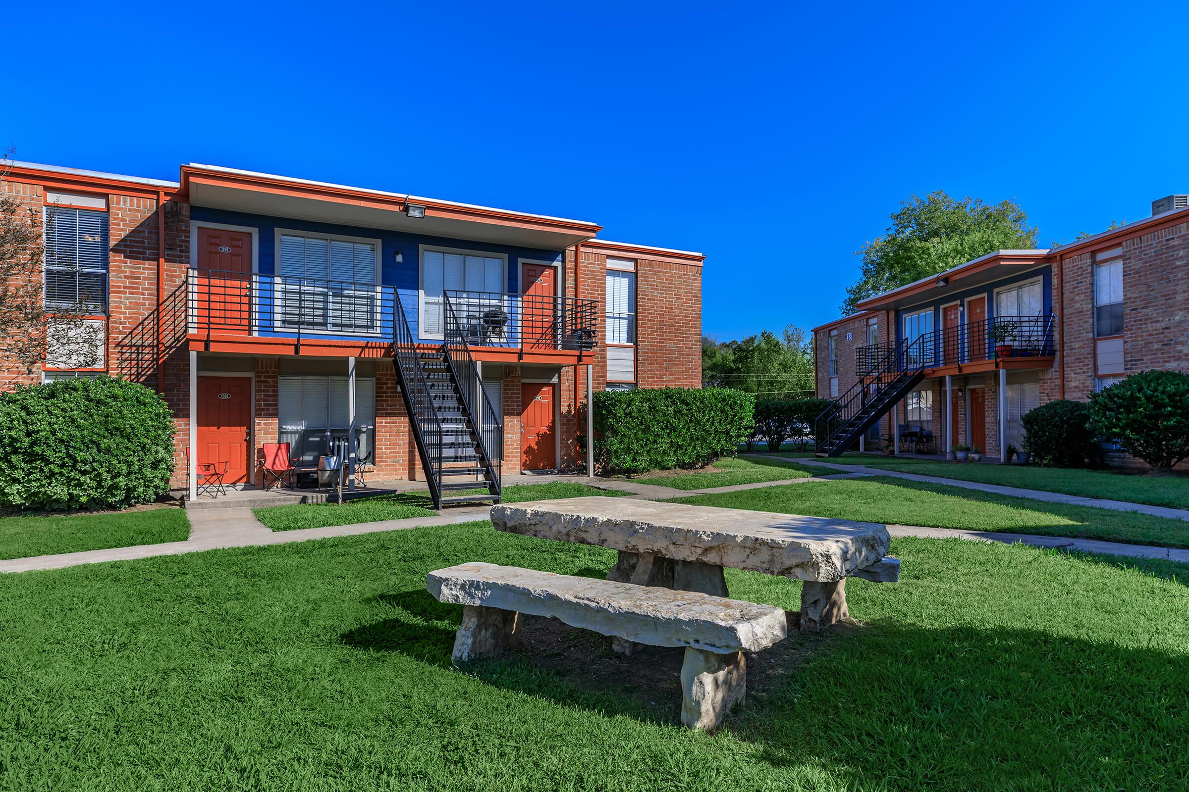 a house with a lawn in front of a brick building