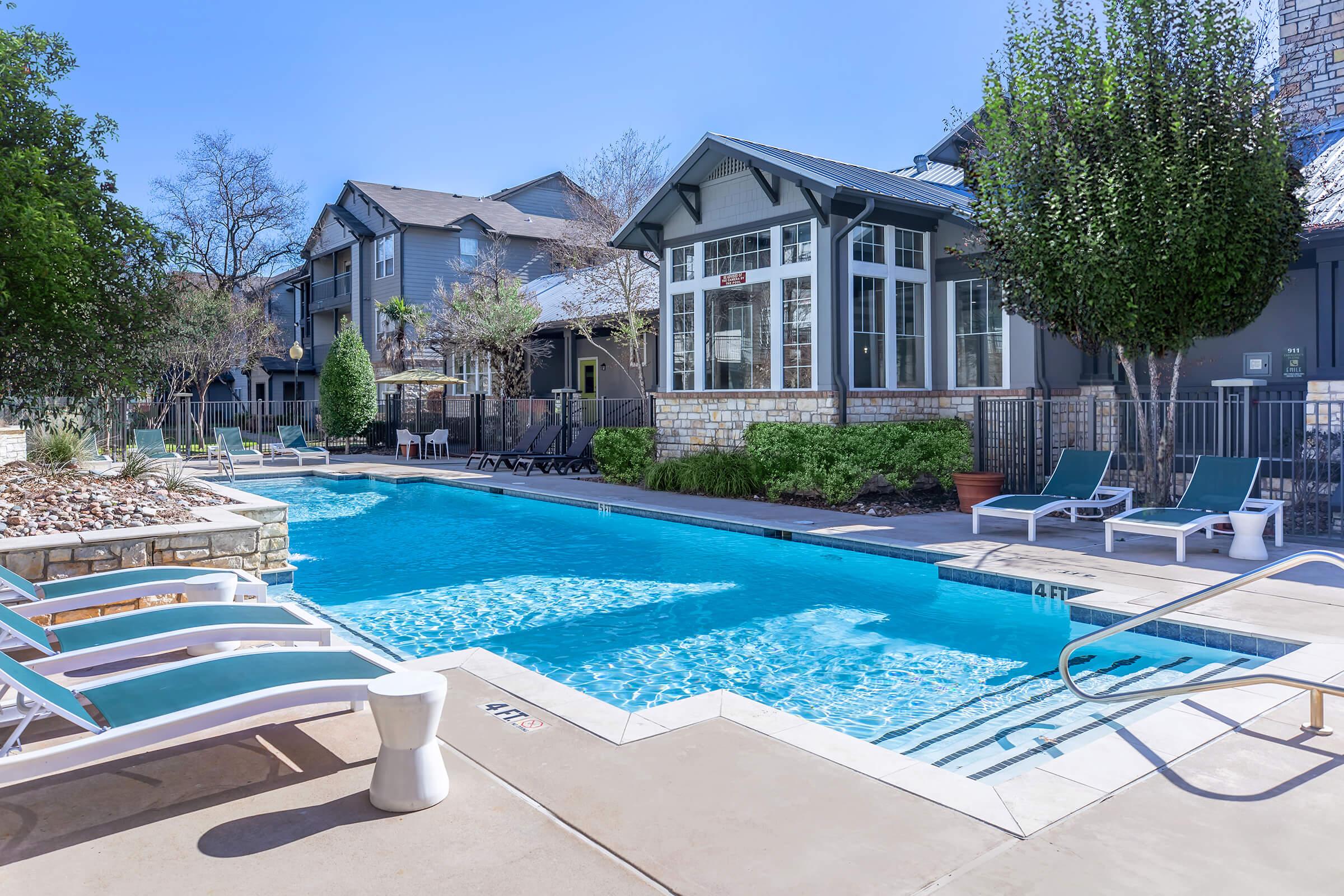 a group of lawn chairs sitting next to a pool