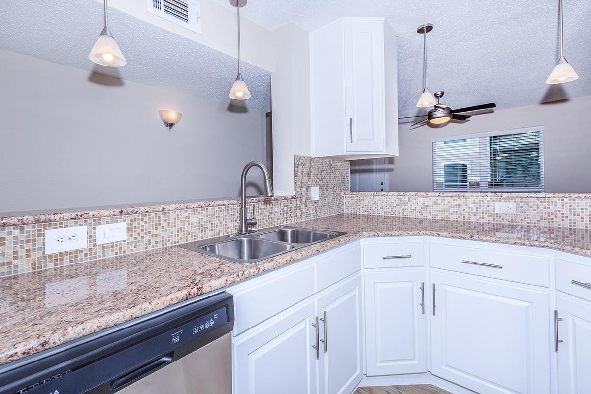 a kitchen with white cabinets and appliances