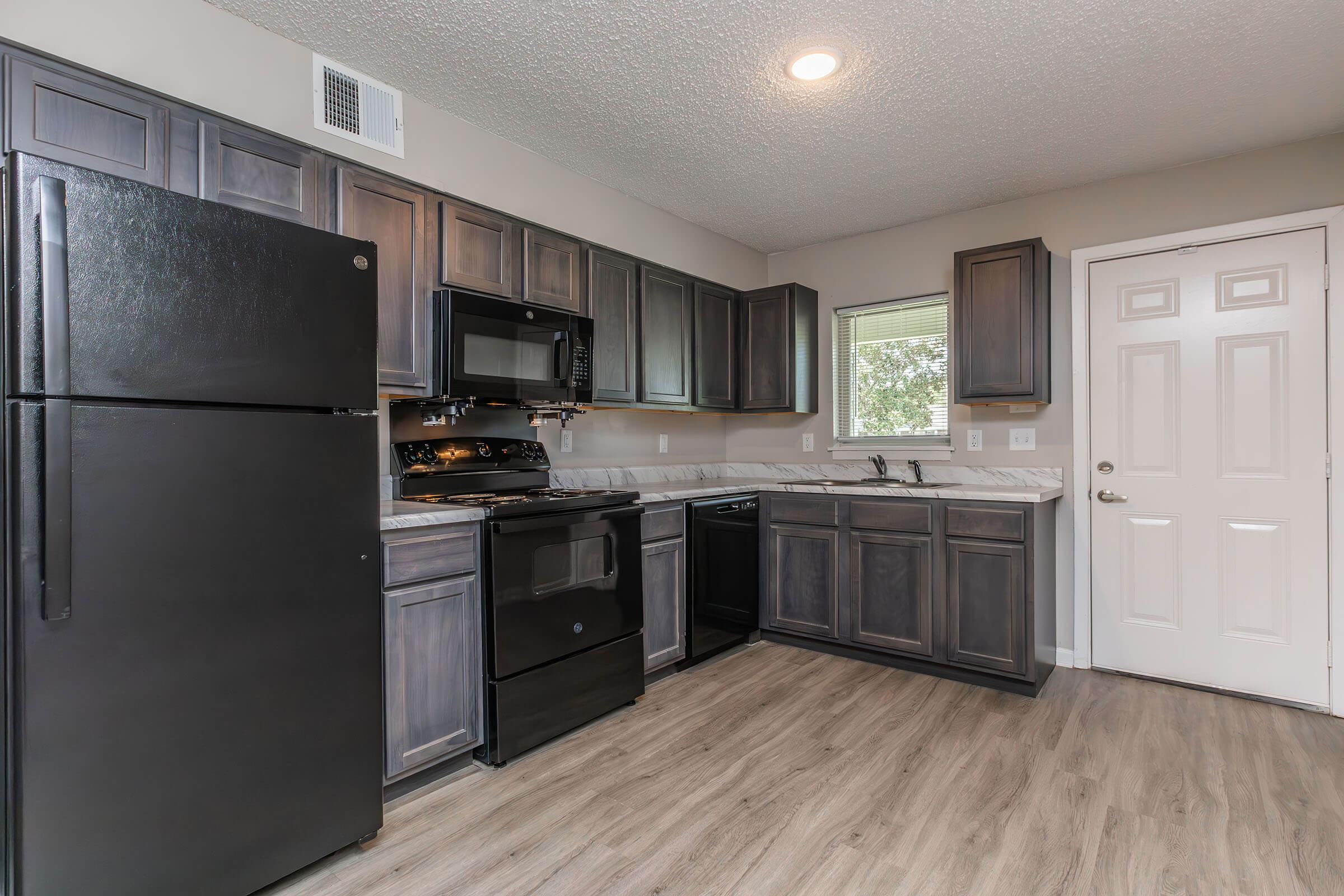 a large kitchen with stainless steel appliances and wooden cabinets