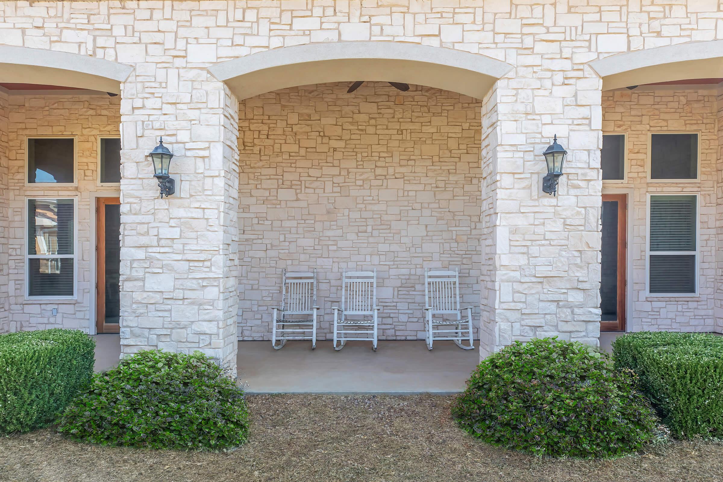 a stone bench sitting in front of a brick building