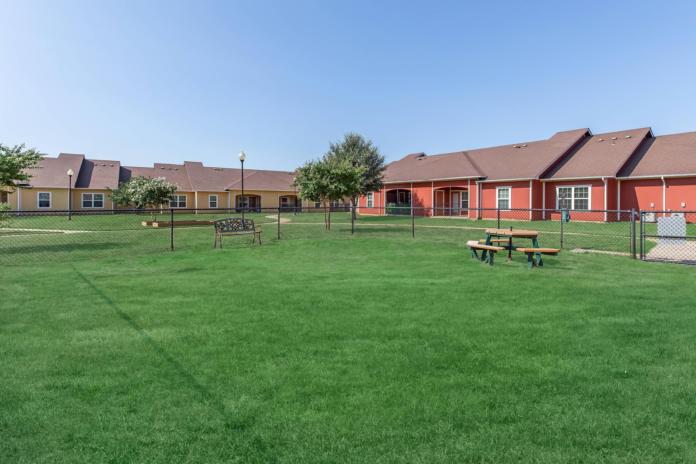 a large green field in front of a house