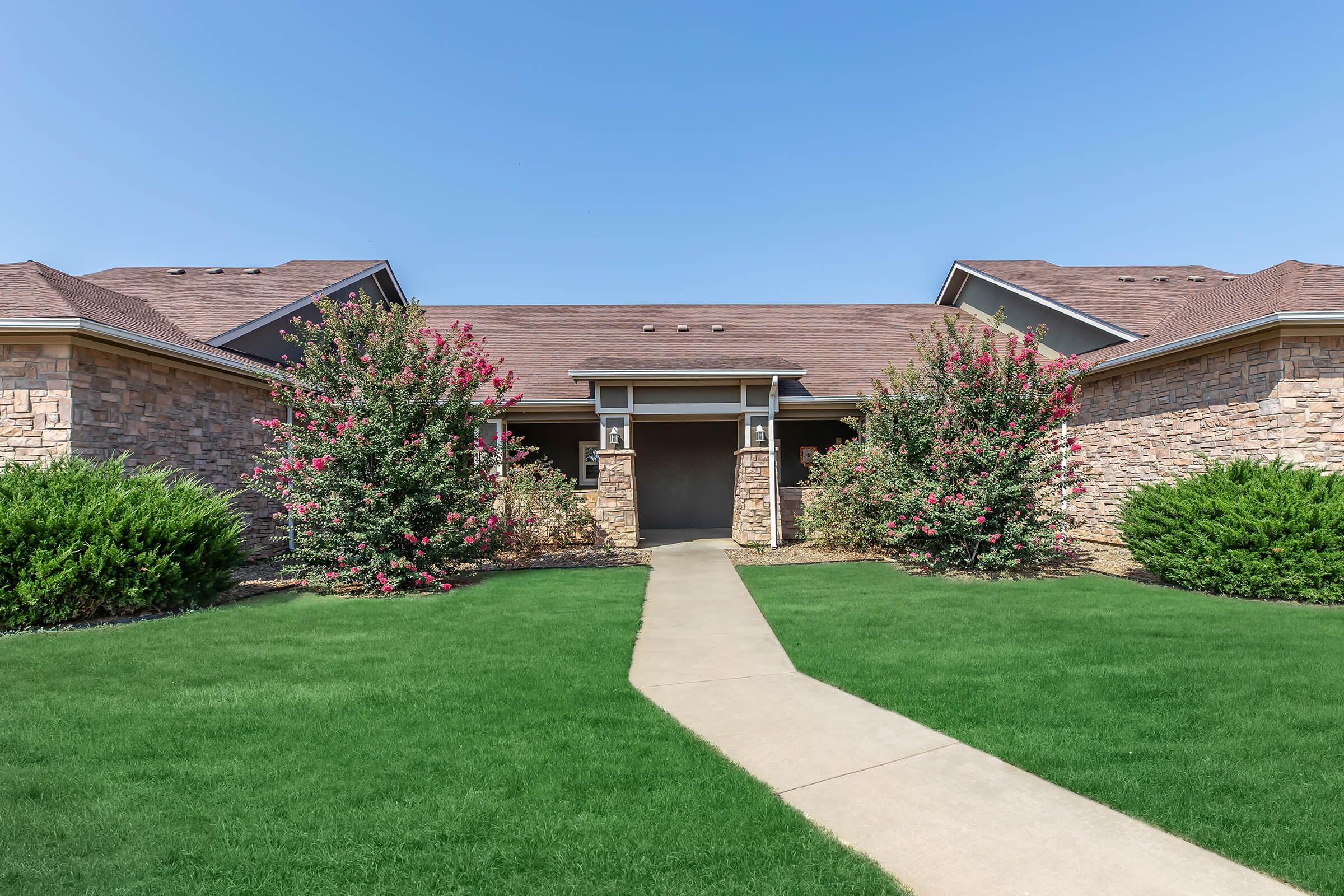 a large lawn in front of a brick building