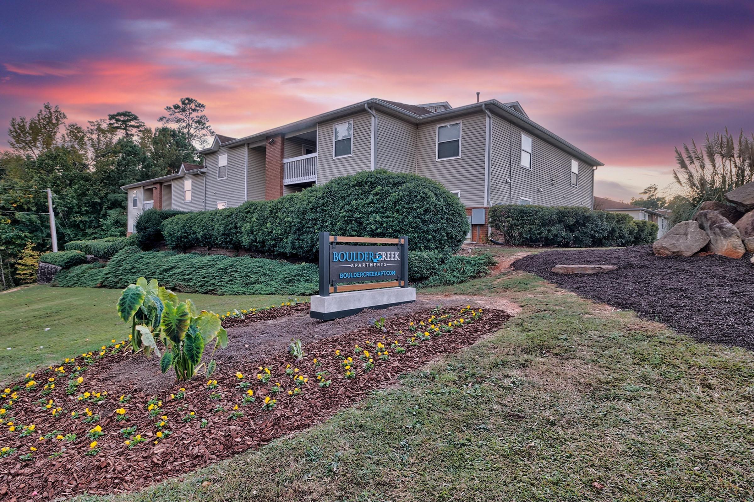 a path with grass in front of a building