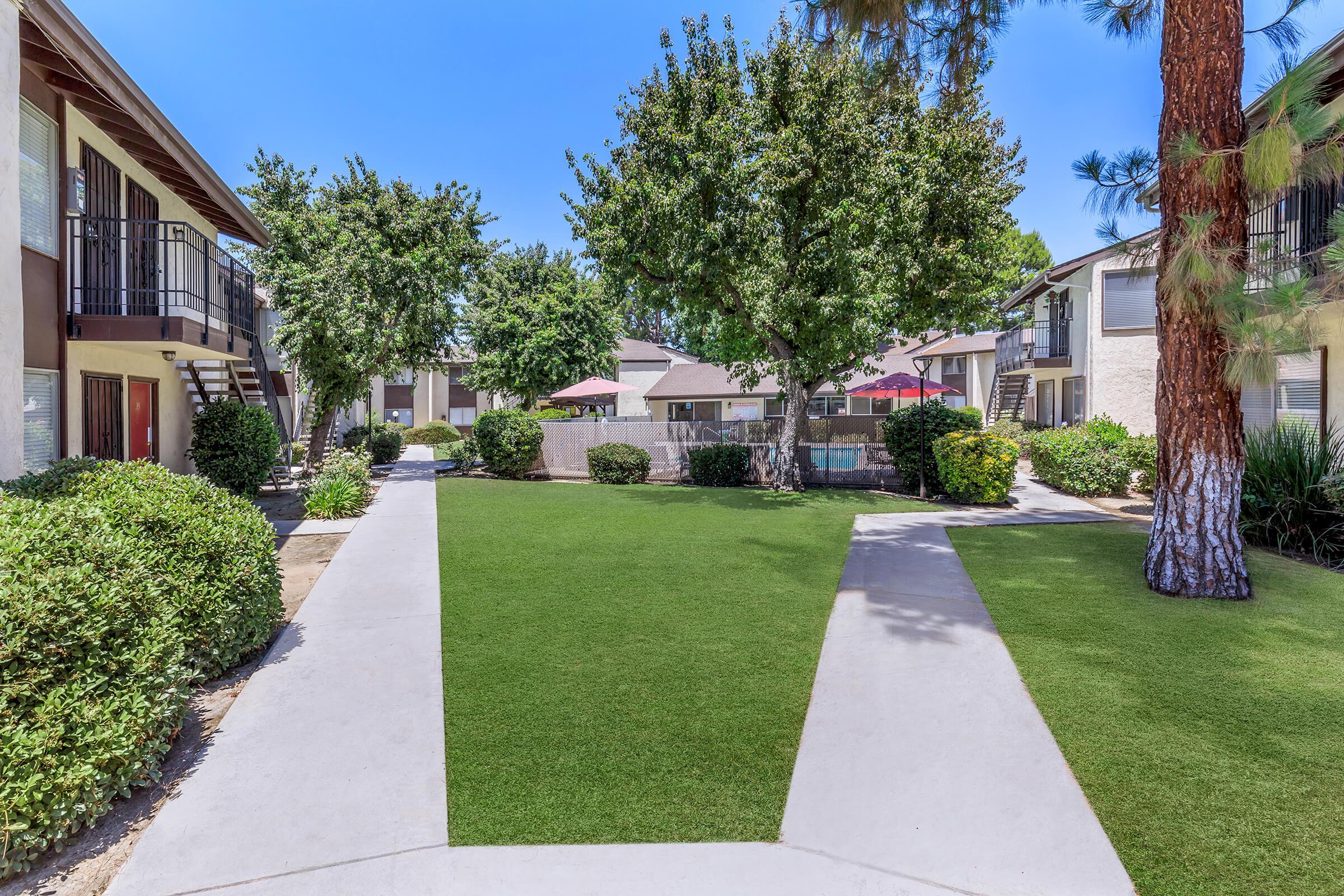 a house with a lawn in front of a brick building