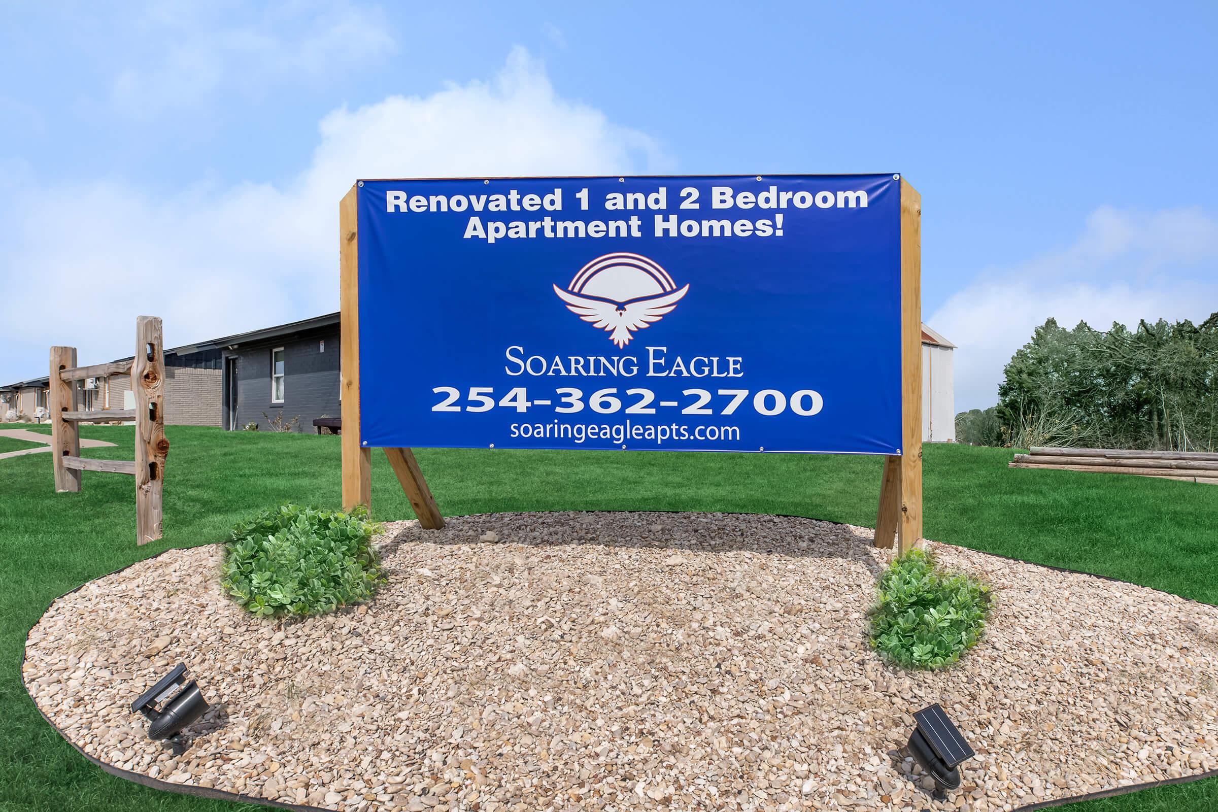 a sign on a dirt field