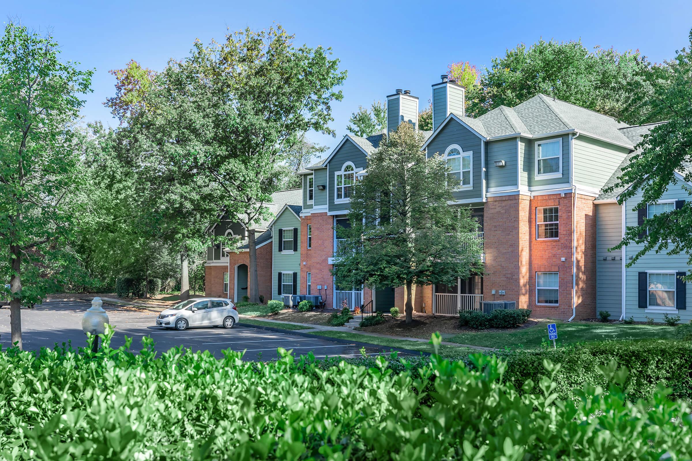 a house with bushes in front of a brick building