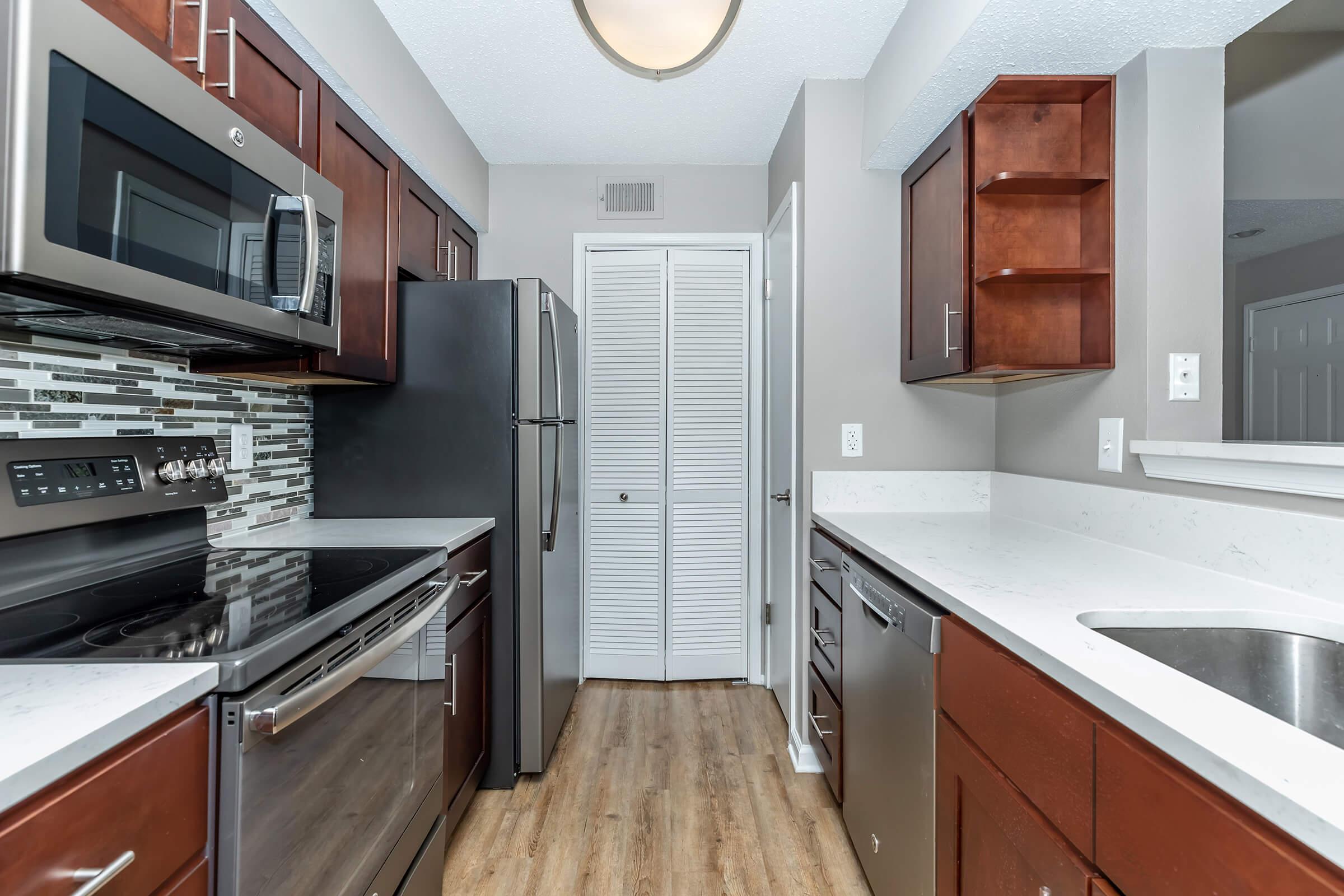 a modern kitchen with stainless steel appliances and wooden cabinets