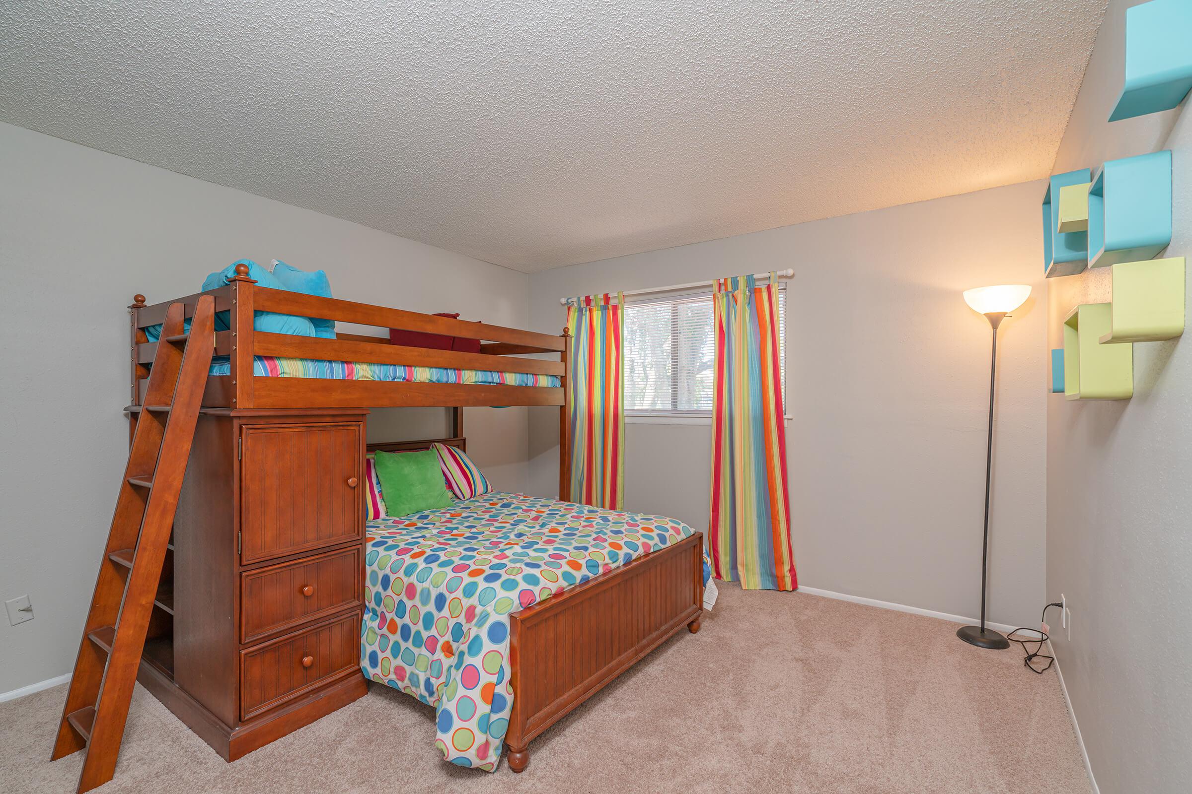 a bedroom with a bed and desk in a room