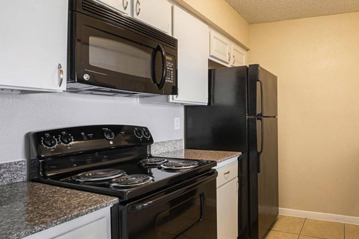 a stove top oven sitting inside of a kitchen with stainless steel appliances