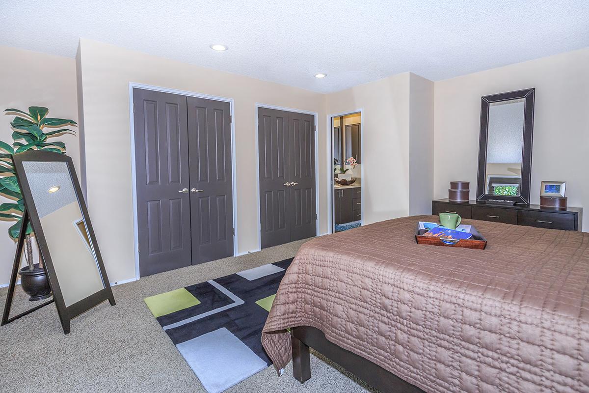 a bedroom with a bed and desk in a room