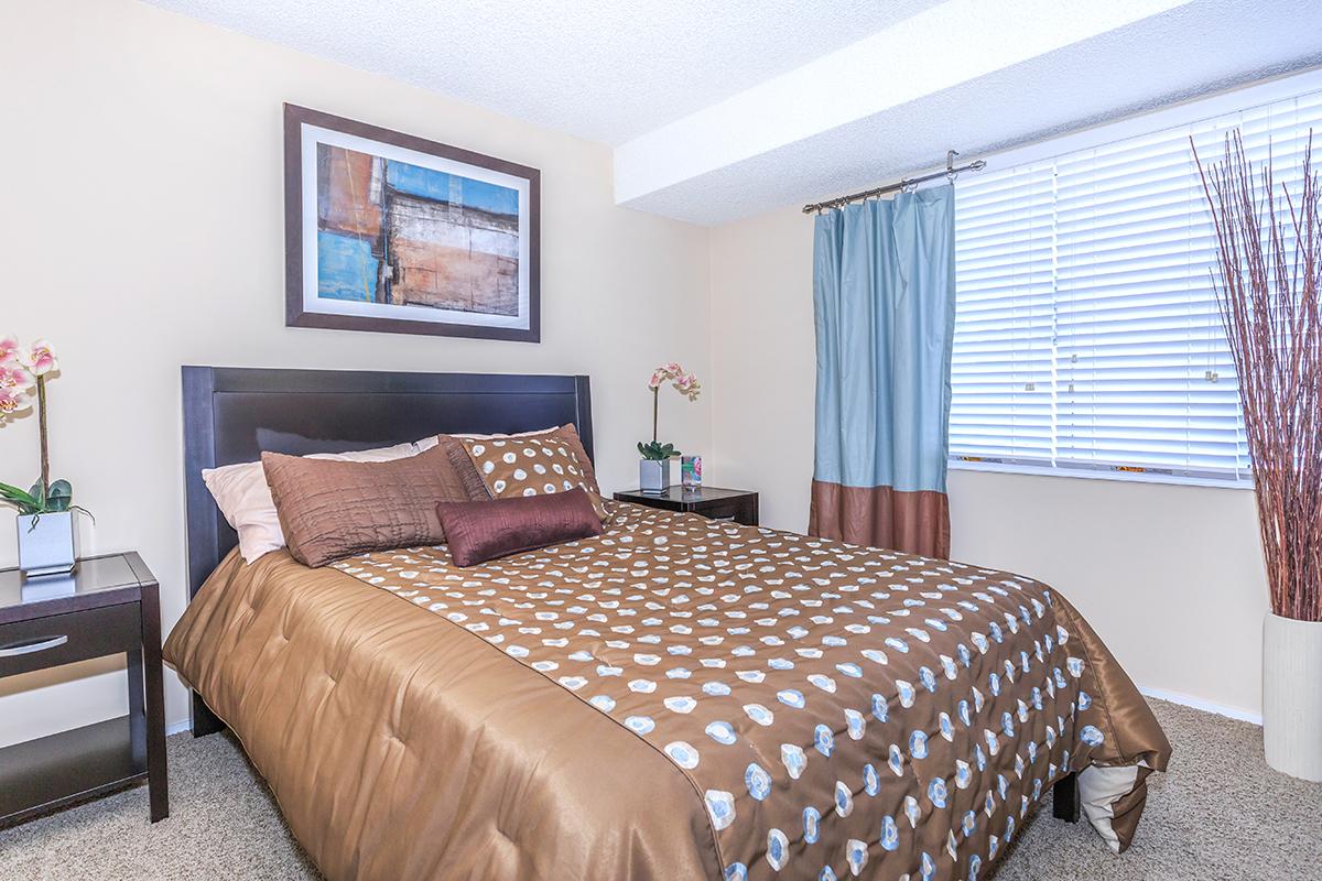 a bedroom with a bed and desk in a hotel room
