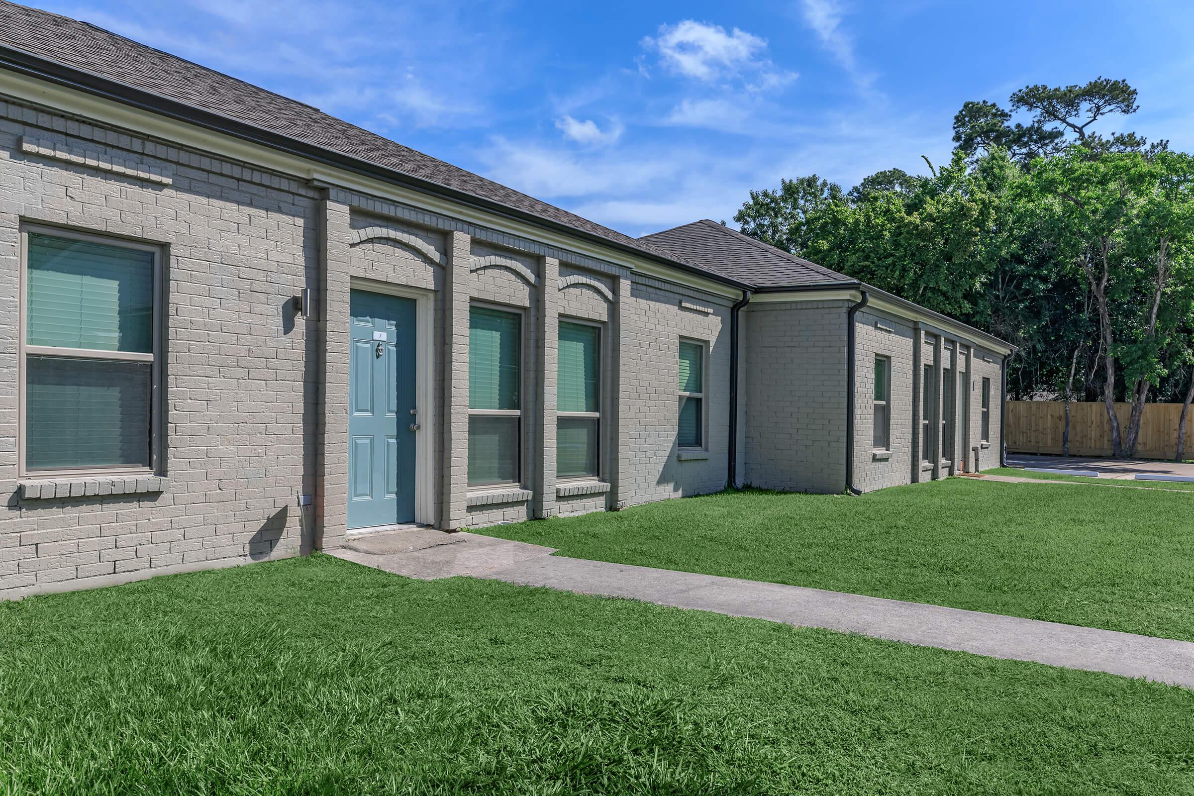 a large lawn in front of a brick building