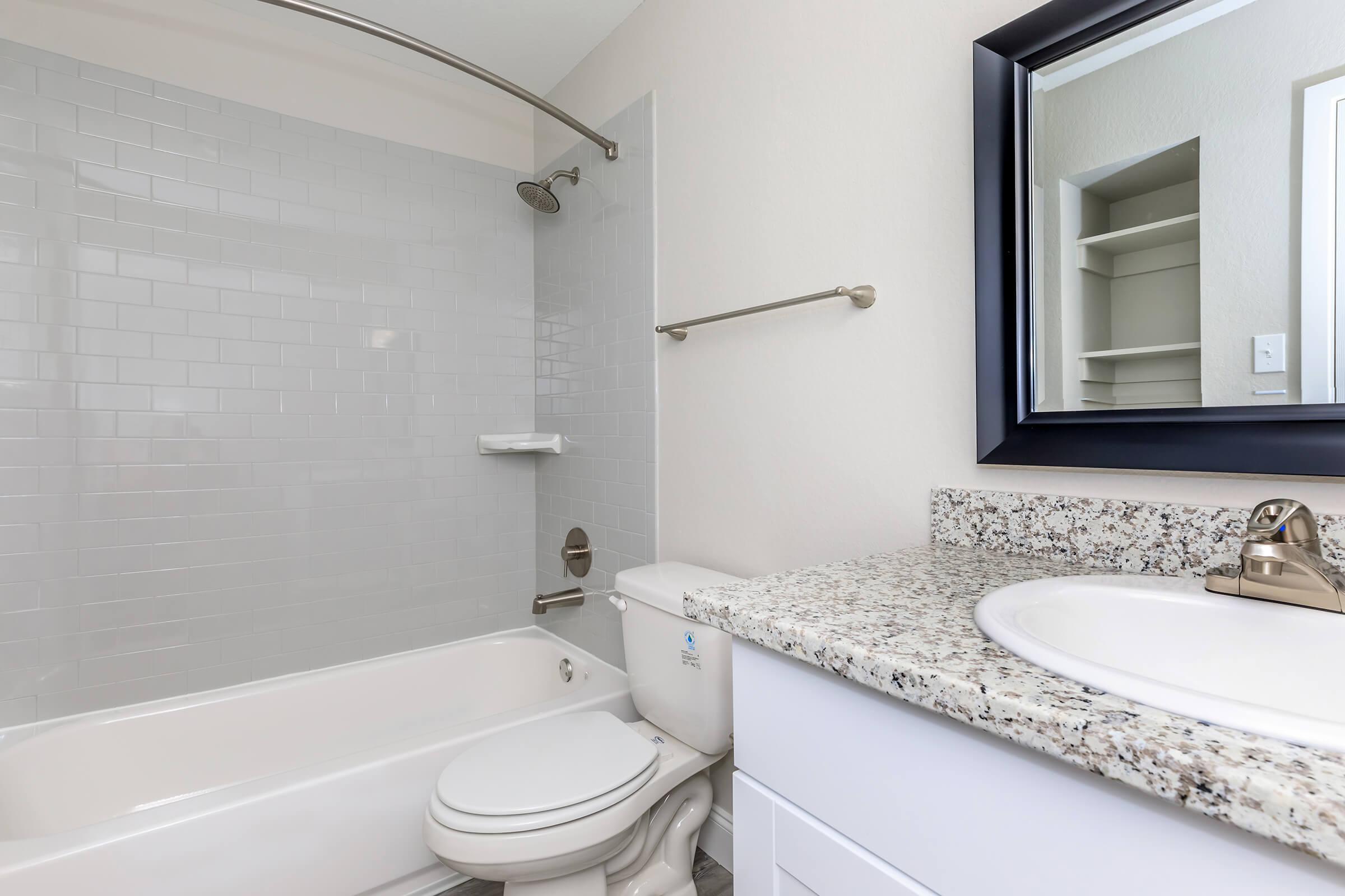 a white sink sitting under a mirror