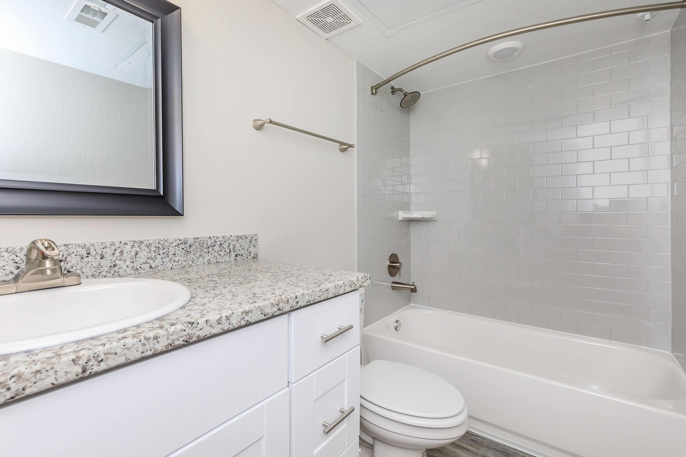 a white sink sitting under a mirror