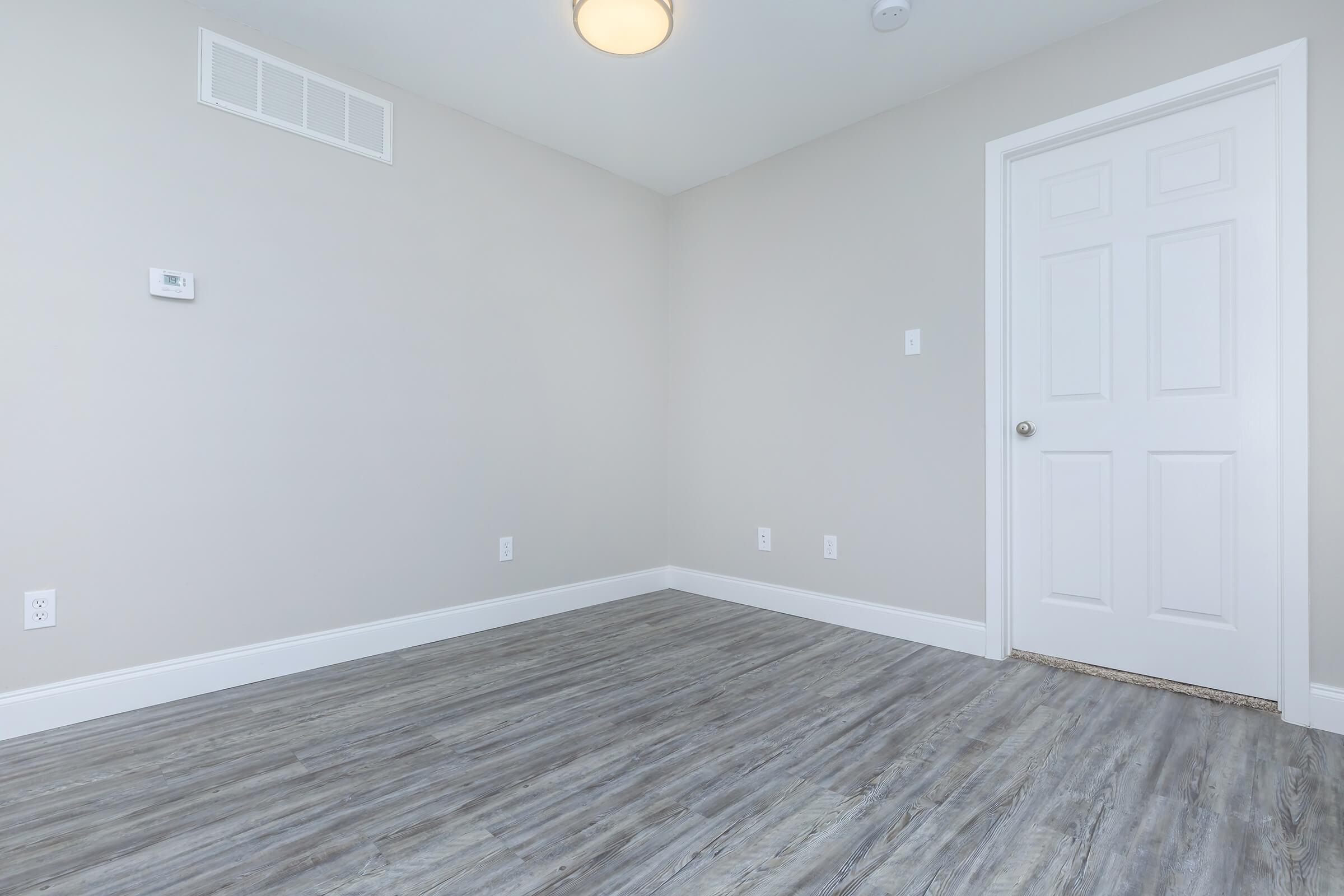 a bedroom with a wooden floor