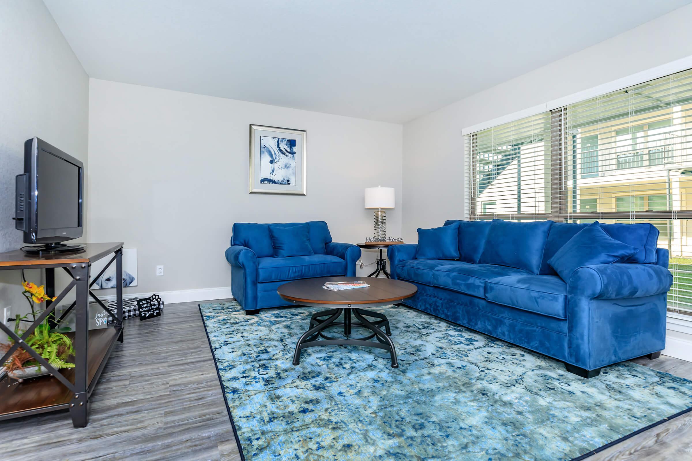 a living room filled with furniture and a large window