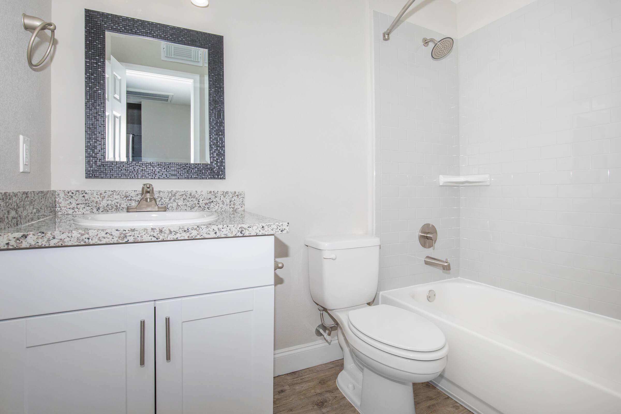 a white sink sitting under a mirror